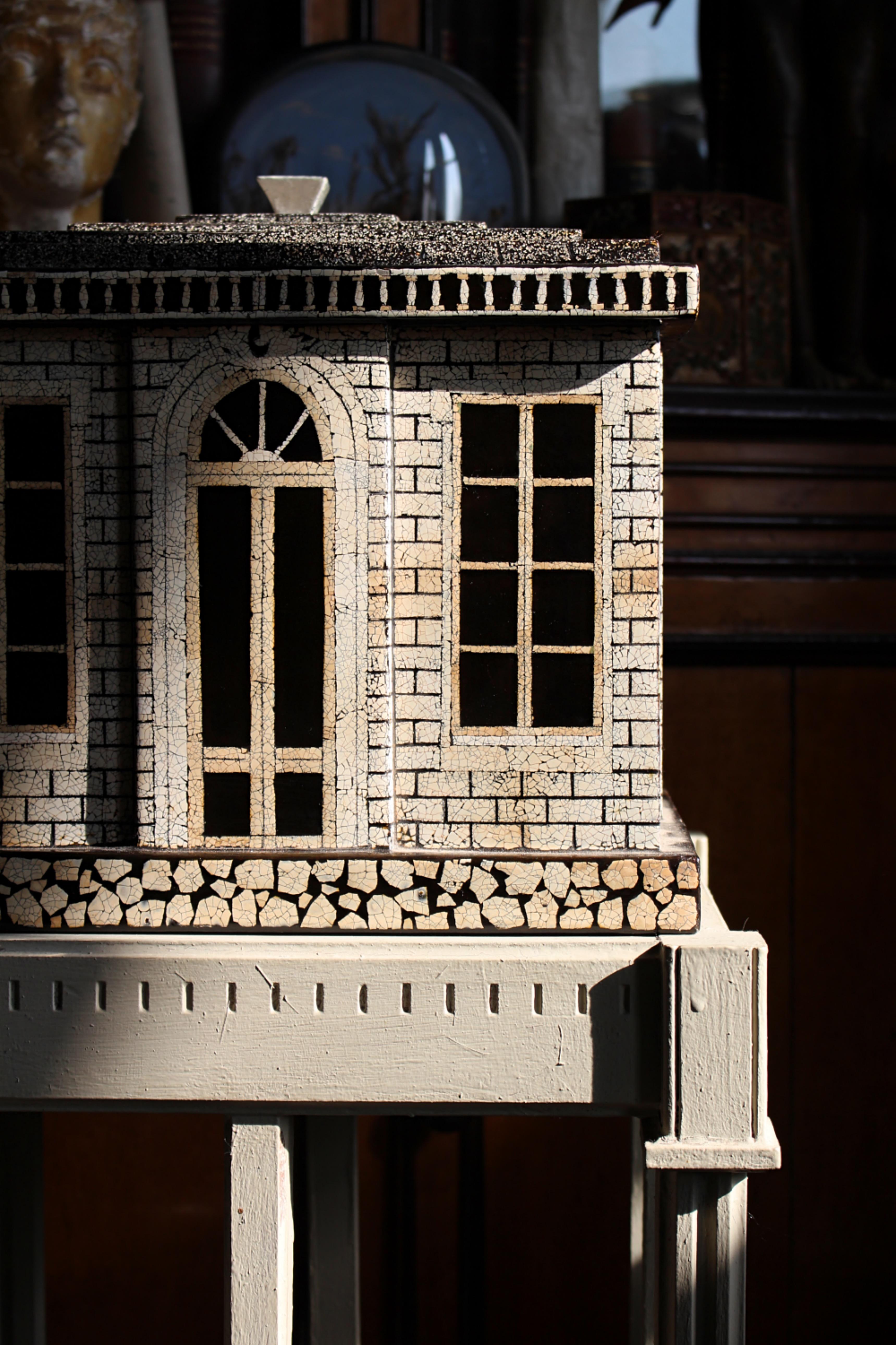 Ein wunderschönes Kästchen mit Deckel in Form eines georgianischen Hauses. Der Holzkorpus ist mit einem Mosaik aus Eierschalen lackiert.

Der Stufendeckel/das Stufendach lässt sich anheben und gibt einen Innenraum frei.

Produziert von dem