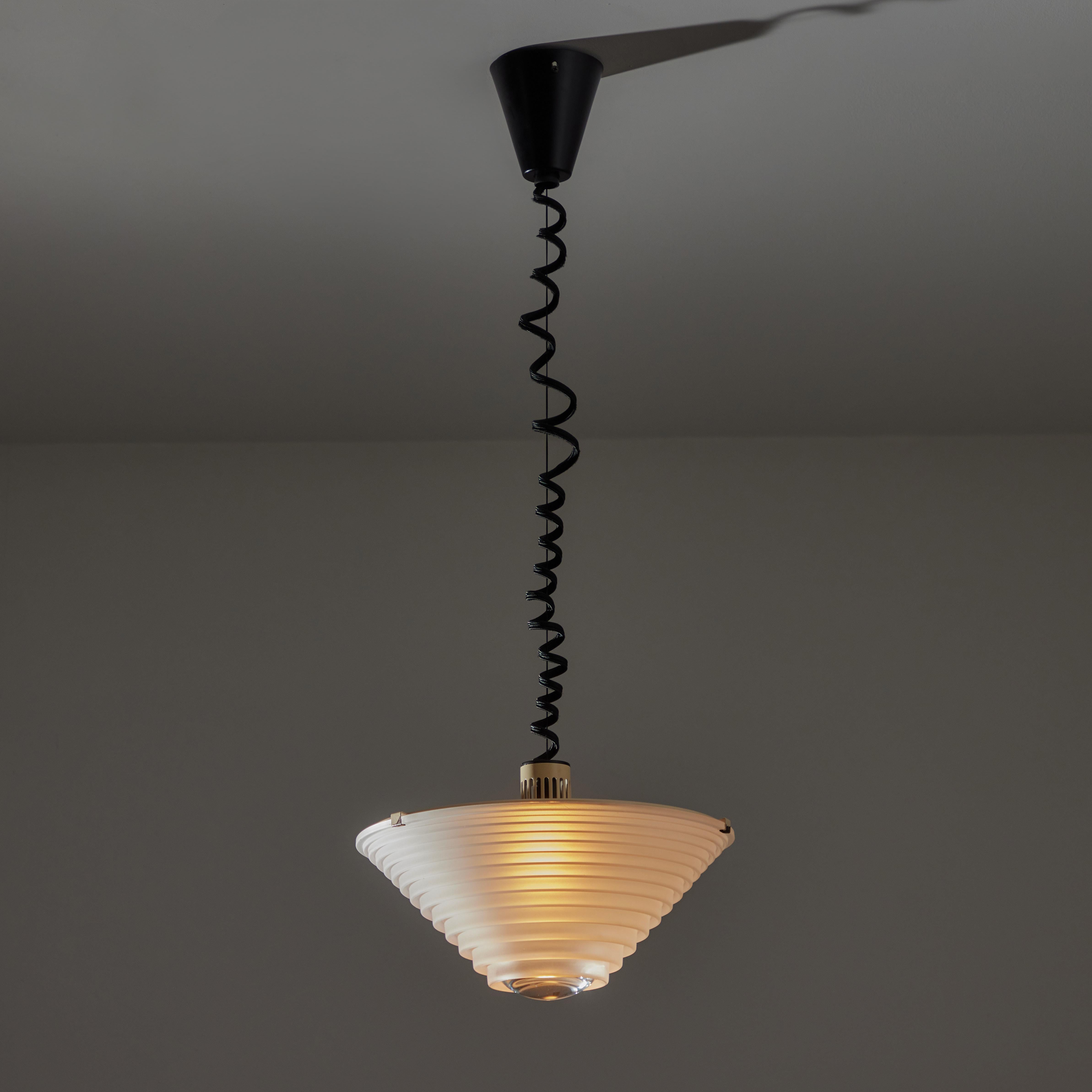 ‘Egina’ Pendant by Angelo Mangiarotti for Artemide. Designed and manufactured in Italy in 1979. Etched molded glass with a tiered typography. Enameled top electrical body and pigtail lamp cord. Height adjustable while installed by patented pulley