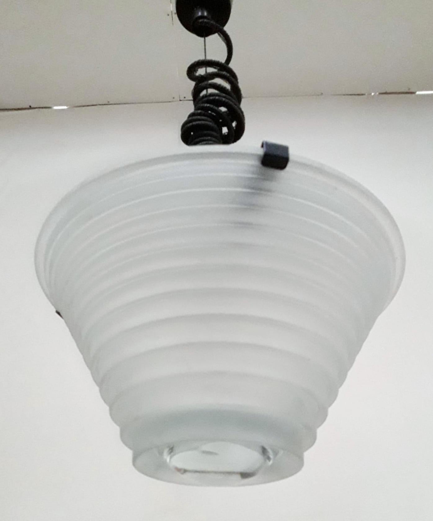 Italian vintage pendant with white sanded glass shade and clear glass lens, suspended from original black adjustable cable and ceiling canopy / Designed by Angelo Mangiarotti for Artemide circa 1970s / Made in Italy 
Original label on the frame 
1