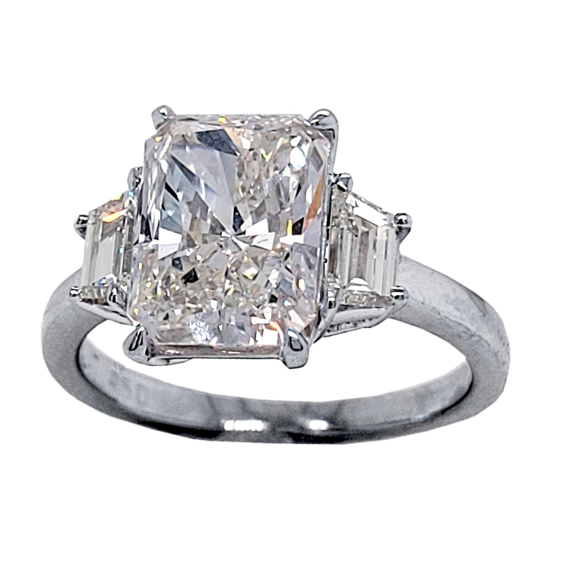 Un magnifique diamant central EGL US Certified Radiant Cut H/VS2 serti dans une belle bague de fiançailles en platine à 3 pierres avec 2 diamants trapézoïdaux sur le côté. Poids total des diamants de 0,58 Ct. diamants sur le côté. 

Caractéristiques
