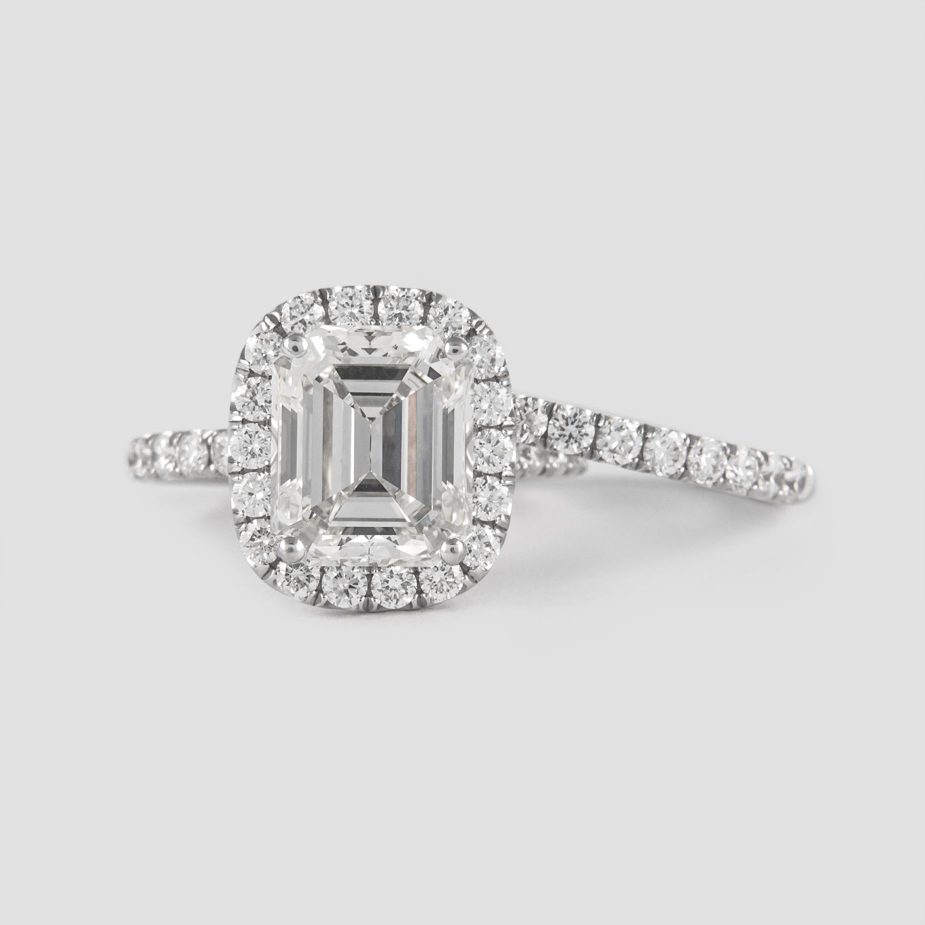 Stunning and classic diamond halo engagement ring with an eternity band, EGL certified.
Center stone, 3.99ct emerald cut diamond. K-L color grade & VS1 clarity grade, EGL certified. Side stones and eternity band consist of round brilliant diamonds,