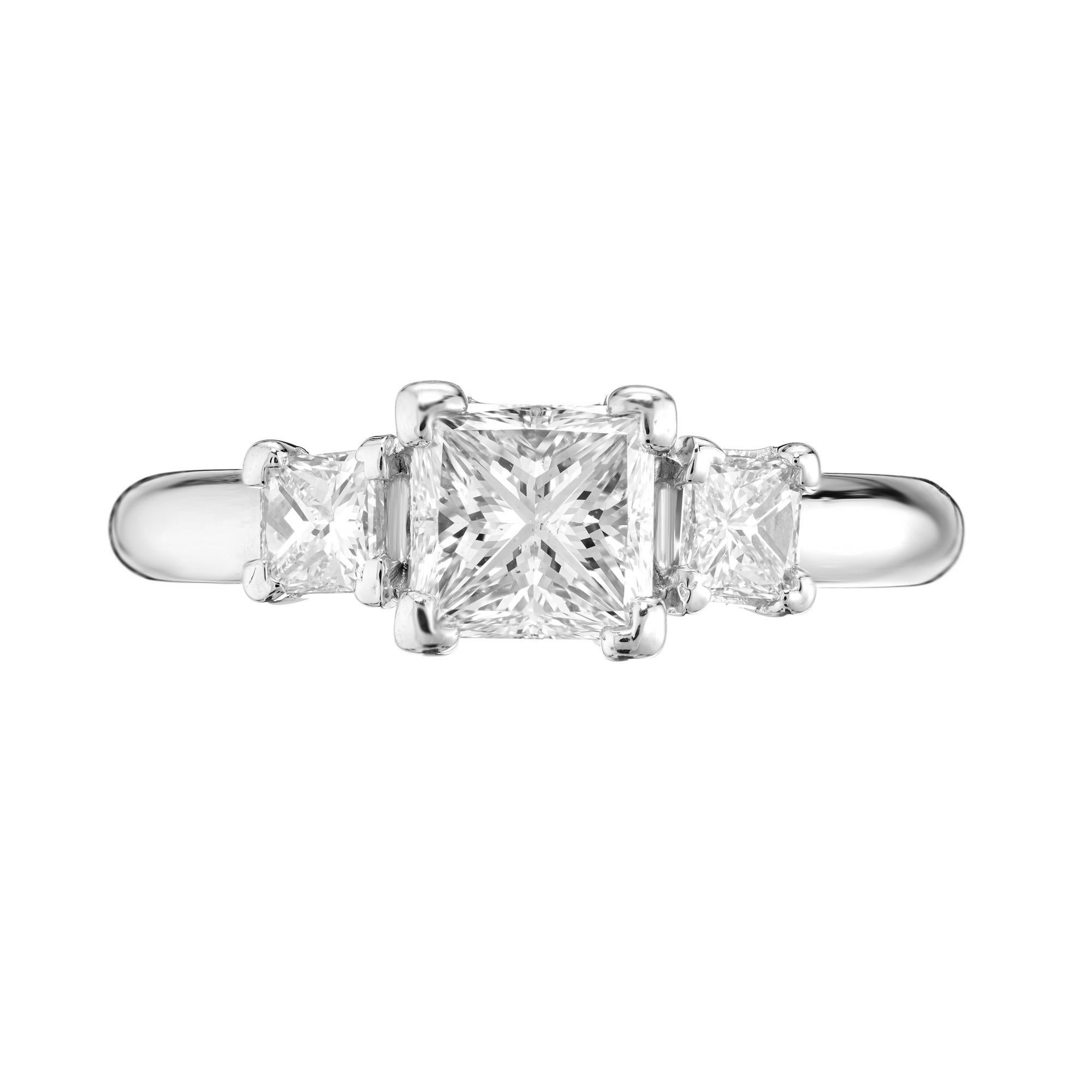 Anillo de compromiso de tres diamantes talla princesa en un engaste de tres piedras en platino. 

1 Diamante central 1,12cts F, SI1, 
2 diamantes talla princesa Aprox. .40cts total F, VS2 a SI1
Talla 7 y talla grande
Platino
Vástago de 3,2 mm
