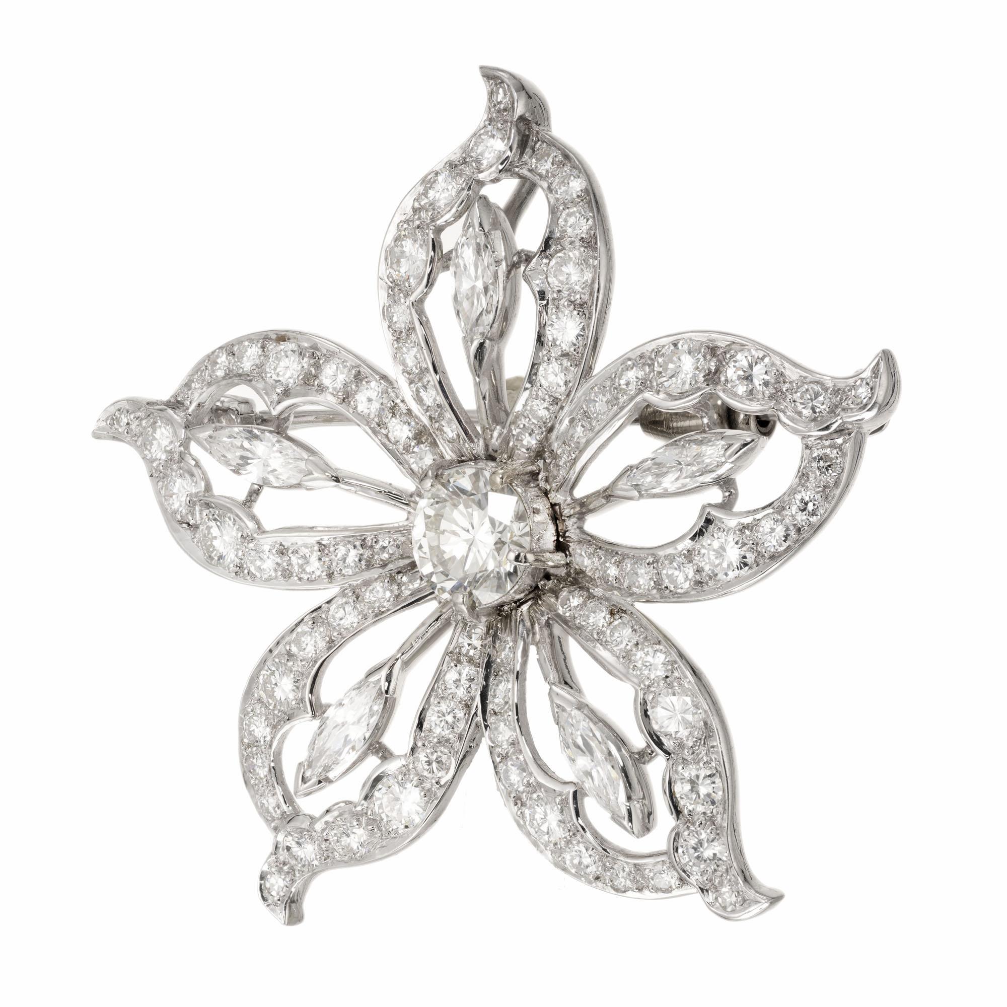 Flower diamond brooch. The EGL certified center 1.20 carat diamond is surrounded by five open petals. Each of the petals has a marquise brilliant cut diamond in the center and is bordered with 16 round cut diamonds varying in sizes. Can be worn as a