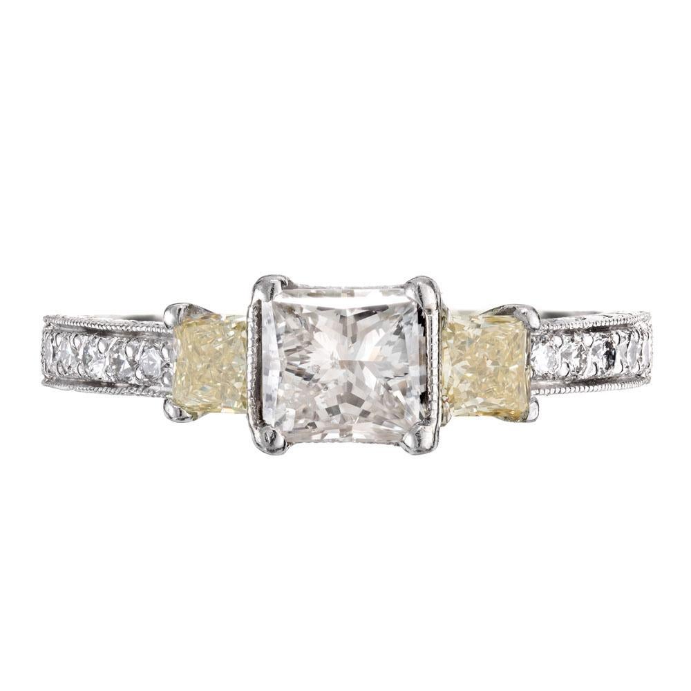 Radiant cut white and yellow diamond engagement. EGL certified center rectangular diamond set in platinum with 2 natural fancy yellow radiant cut side diamonds, accented with 10 round micro pave diamonds along the shoulders. 

1 radiant cut diamond