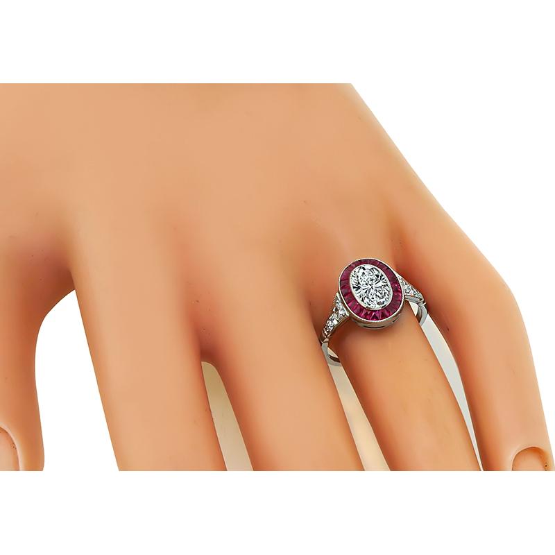 This is an elegant 18k white gold engagement ring. The ring is centered with a sparkling EGL certified oval cut diamond that weighs 1.02ct. The color of the diamond is G with VS1 clarity. The center diamond is accentuated by French cut ruby and