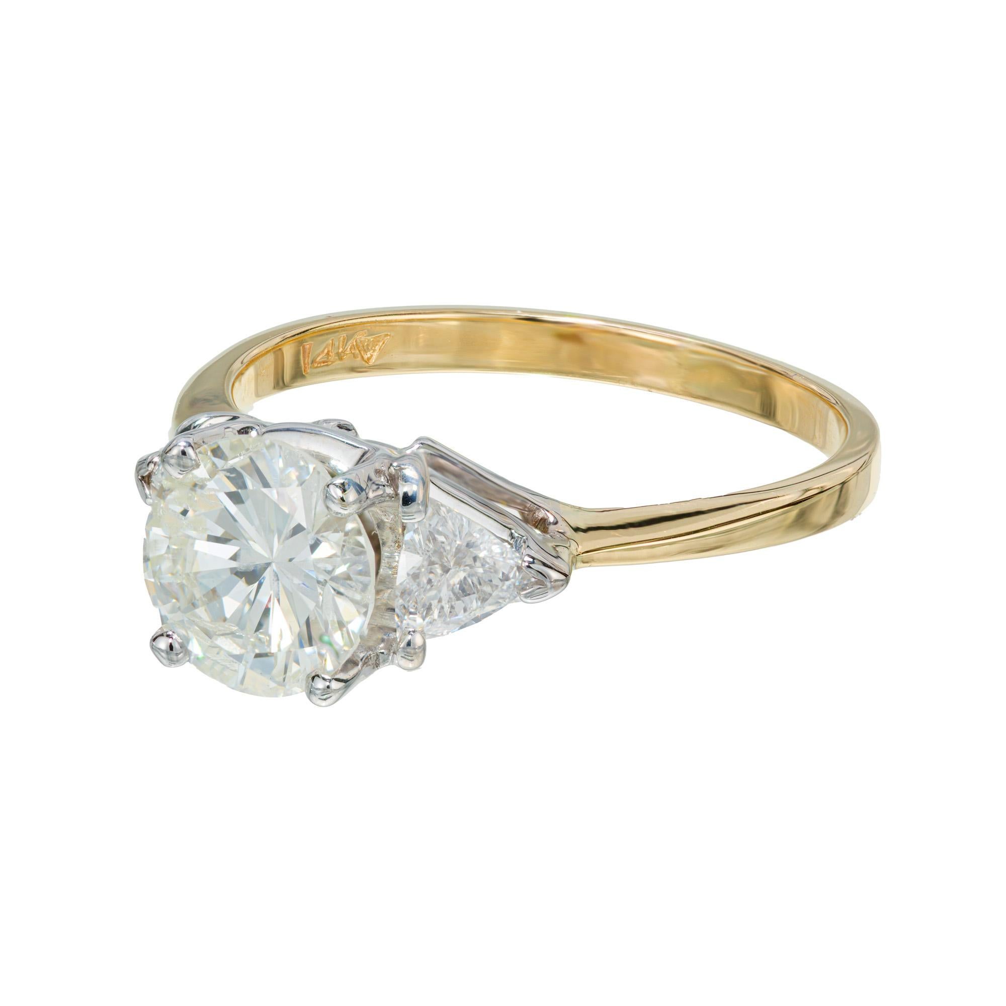 1980's diamond engagement ring. EGL certified 1.20cts round brilliant cut, H-I (near colorless) center diamond set in a 14k white gold crown with a 14k yellow gold shank. Complemented with two trilliant cut diamonds. 

1 round brilliant cut