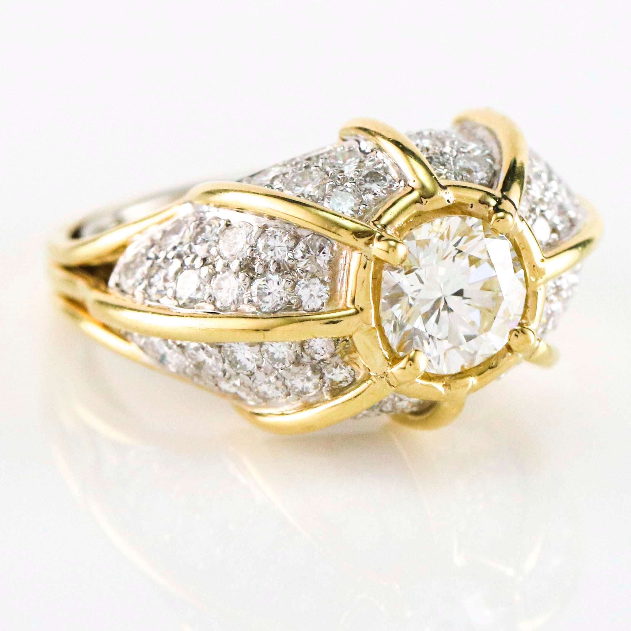 Dome ring bezel set with a 1.29 carat EGL certified round brilliant diamond, pave set with 2.40 carats of round diamonds crafted in 18 karat yellow gold and platinum. Size 6.75. Diamonds, VS-SI G-H.