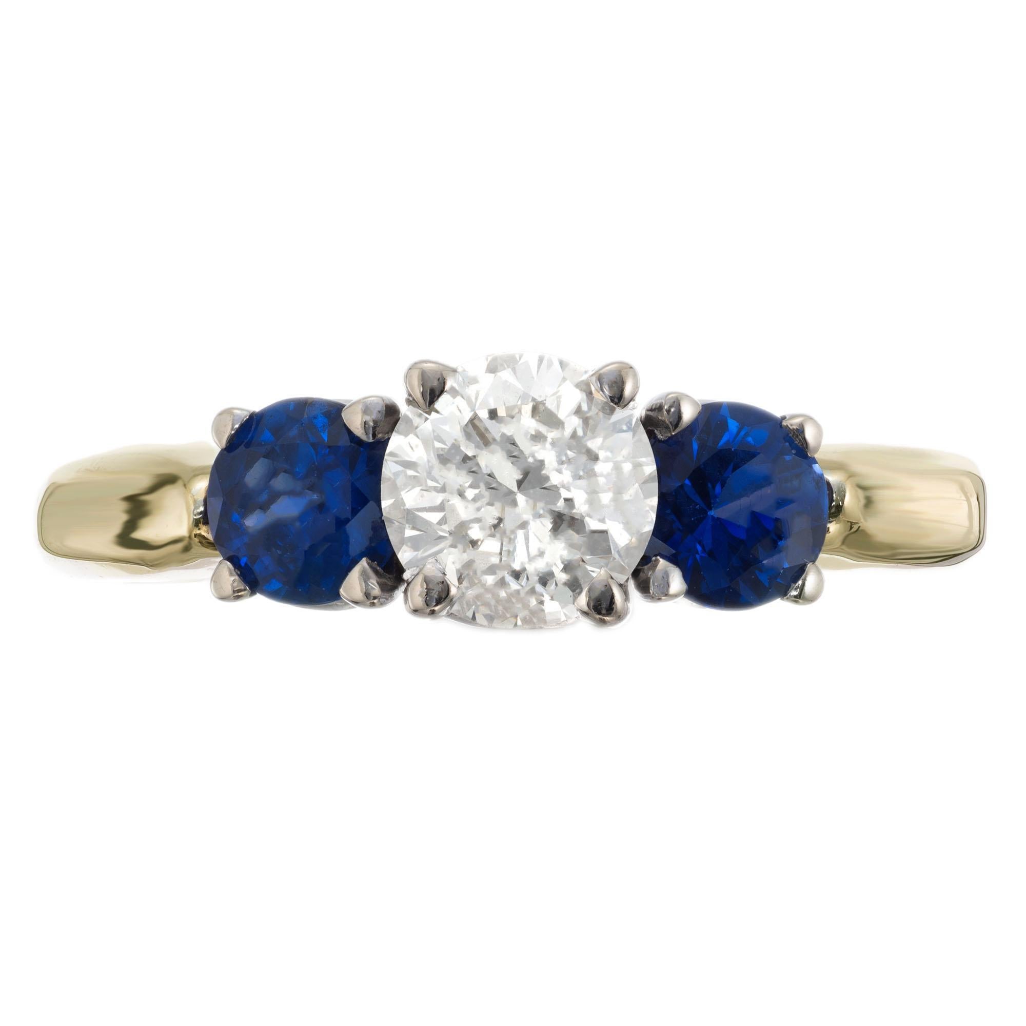 Bague de fiançailles en diamant et saphir à trois pierres. Diamant central rond brillant accentué par 2 saphirs ronds dans une bague en or jaune à monture basse avec une couronne en or blanc. Certifié EGL

1, .63ct diamant rond brillant, K, SI2,