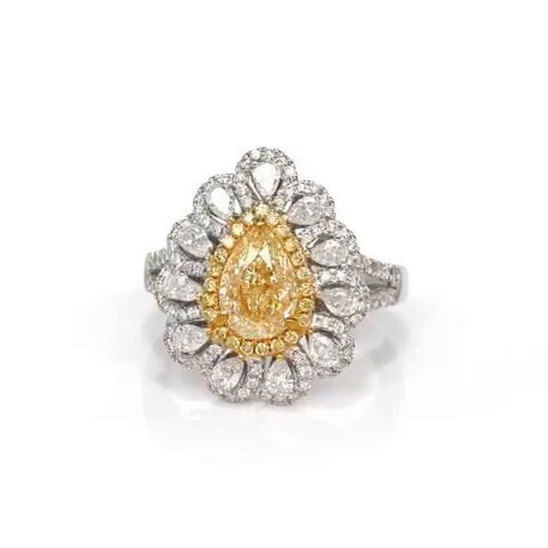 This exquisite 2.93 total carat handcrafted diamond engagement ring is as unique as the hand destined to wear it. At its center, a breathtaking 1.58 carat EGL certified vivid fancy yellow diamond is embraced by 23 round yellow diamonds, all set on