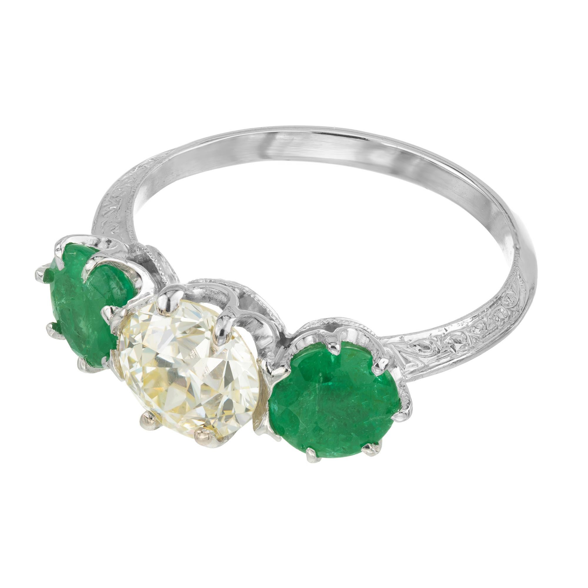 Beautifully crafted 1930's Art Deco three stone diamond and emerald engagement ring. The EGL certified 1.19 carat old European cut diamond is in the center of two bright green emeralds with an approximate total weight of 1.50 carats. The color of