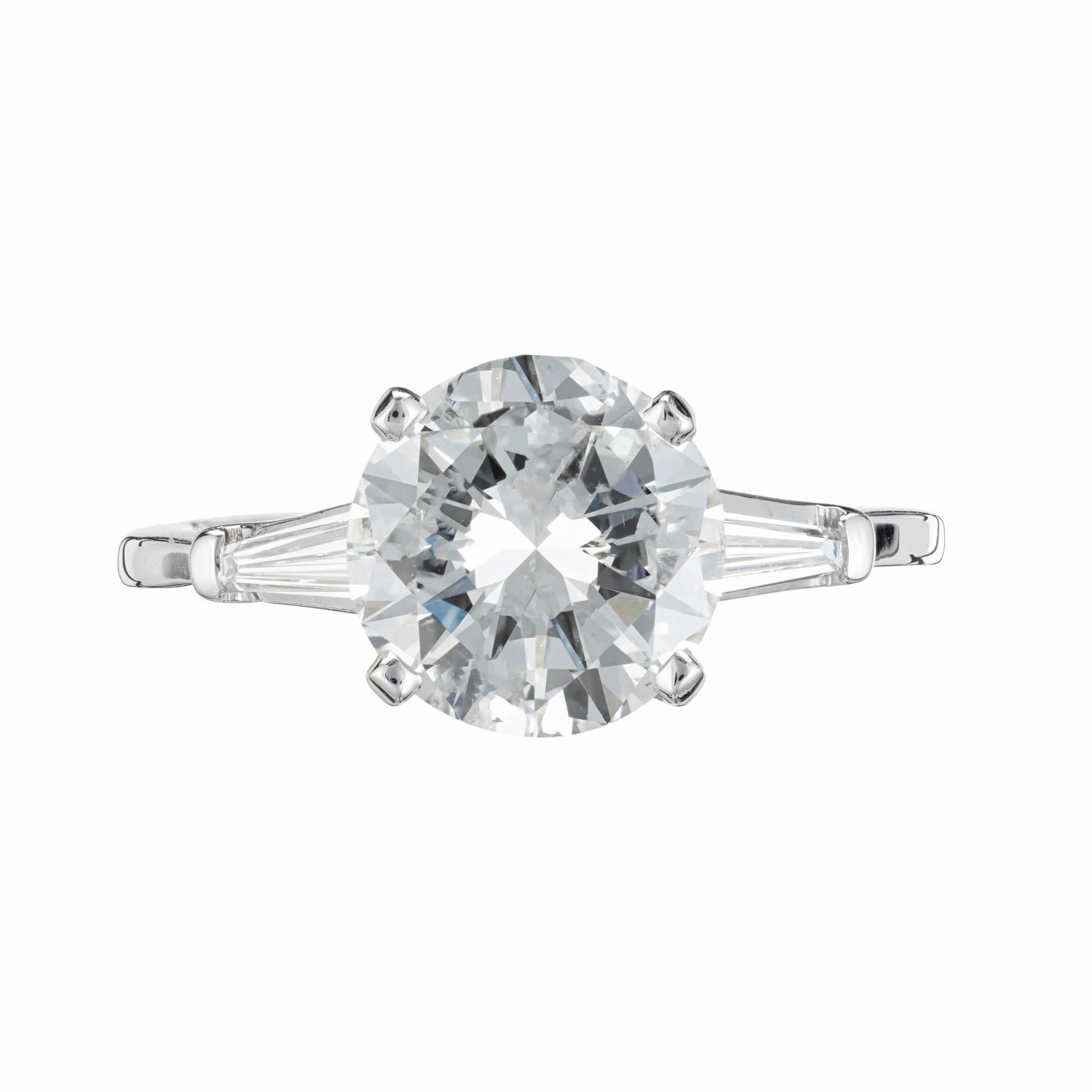 Diamond three-stone engagement ring. EGL certified 2.71ct round brilliant cut center diamond in a simple four prong platinum setting with two tapered baguette accent diamonds. The main diamond has great brilliance and is graded H-I. Classic