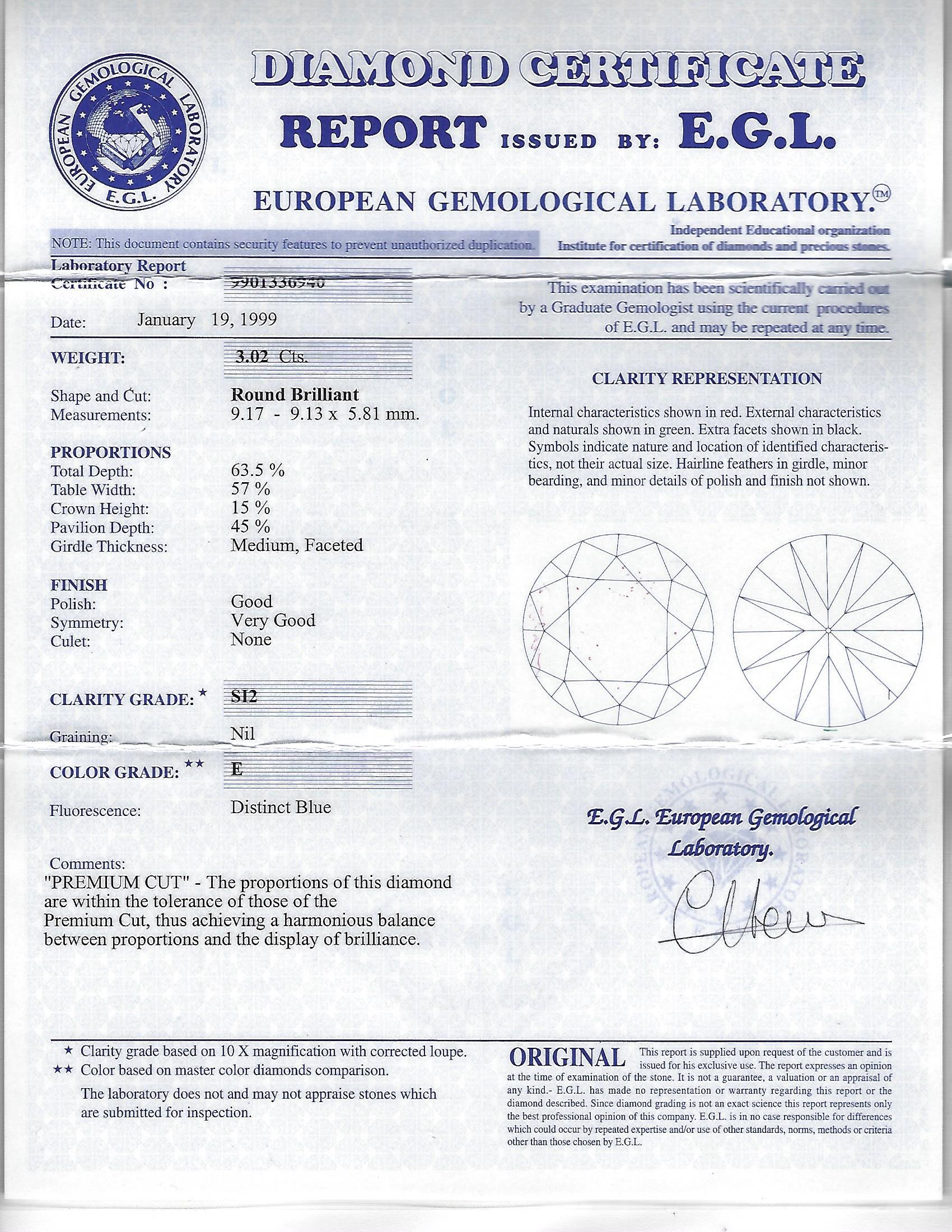 Serti dans de l'or blanc 18 carats, pesant 3,50 grammes, se trouve un diamant rond de 3,02 carats taillé en brillant, 
Certificat EGL #9901336940, Gamme de couleurs de : E, degré de pureté de : SI-2. 
L'anneau est également rehaussé de deux diamants