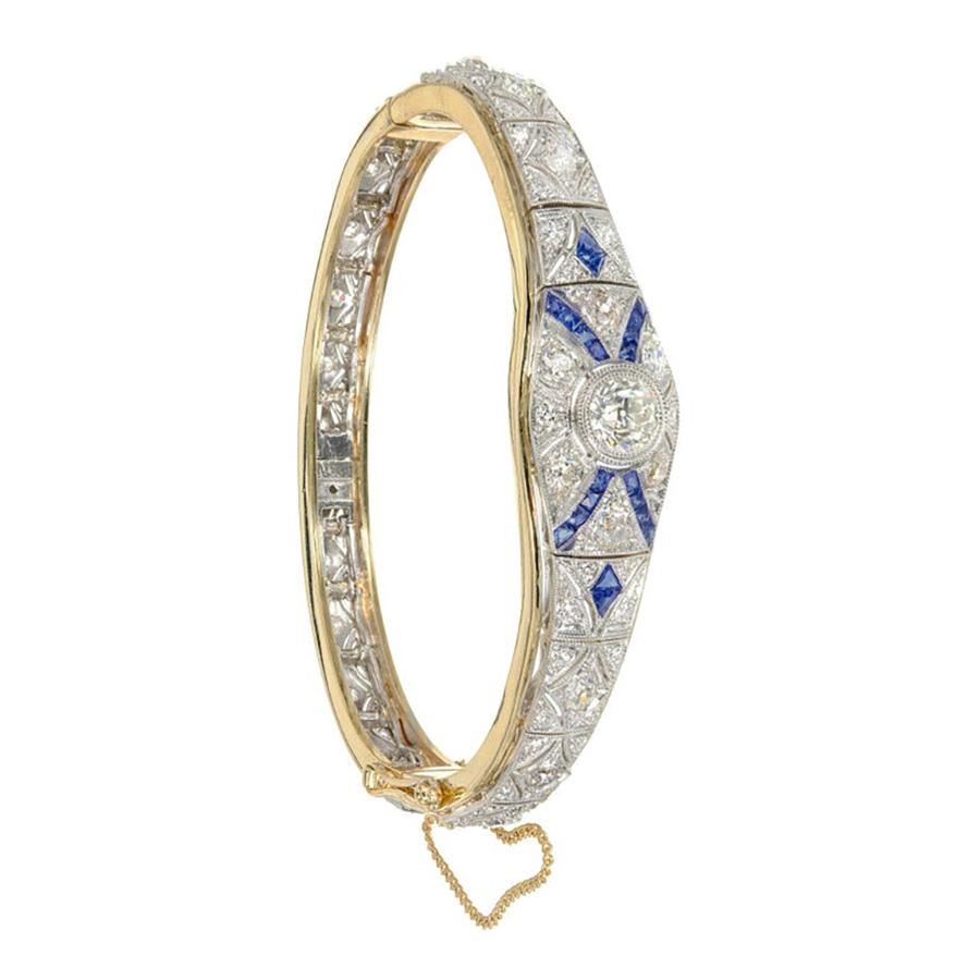 Diamond and sapphire Art Deco bangle bracelet. Platinum hinged link filigree mounted on top of a simple 14k yellow gold Hinged bracelet. The original platinum bracelet is circa 1910-1920 later mounted on to the yellow gold bangle from 1940's era.