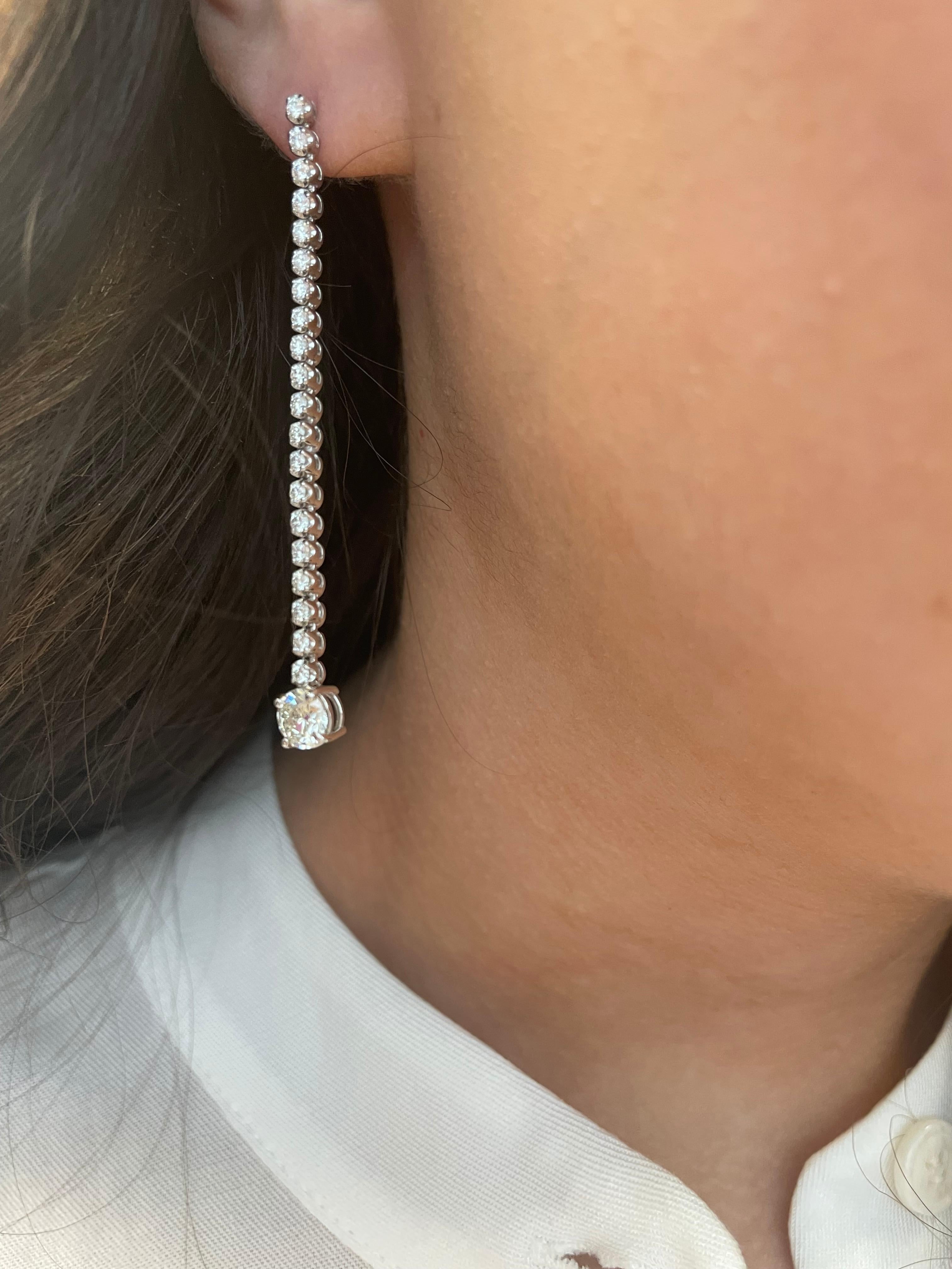 Stunning dangling diamond earring, each center stone EGL certified. By Alexander Beverly Hills.
Two matching center round brilliant diamonds 1.40 carats total. One stone H color grade and the other I color grade. One stone SI1 clarity grade and the