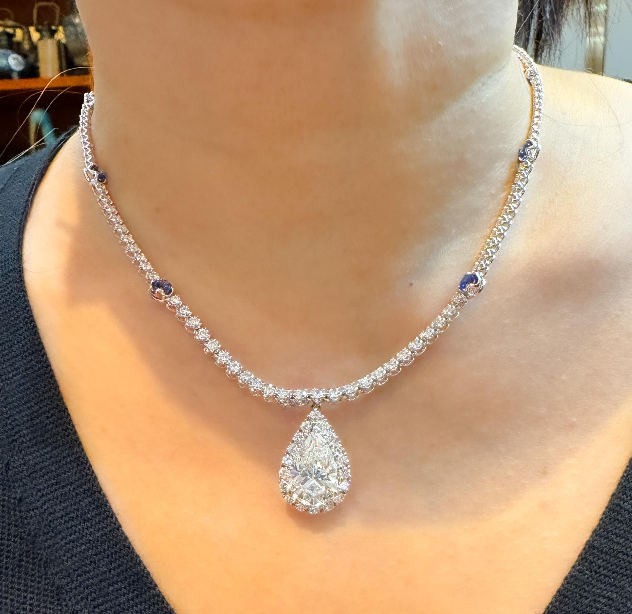EGL Certified Pear Diamond Pendant and Diamond Halo & Sapphire Detail. 

Pendant necklace featuring a EGL-certified pear-shaped 5.02-carat natural white diamond center stone with SI2 clarity and G color. Surrounded by 18 round-cut diamond halo