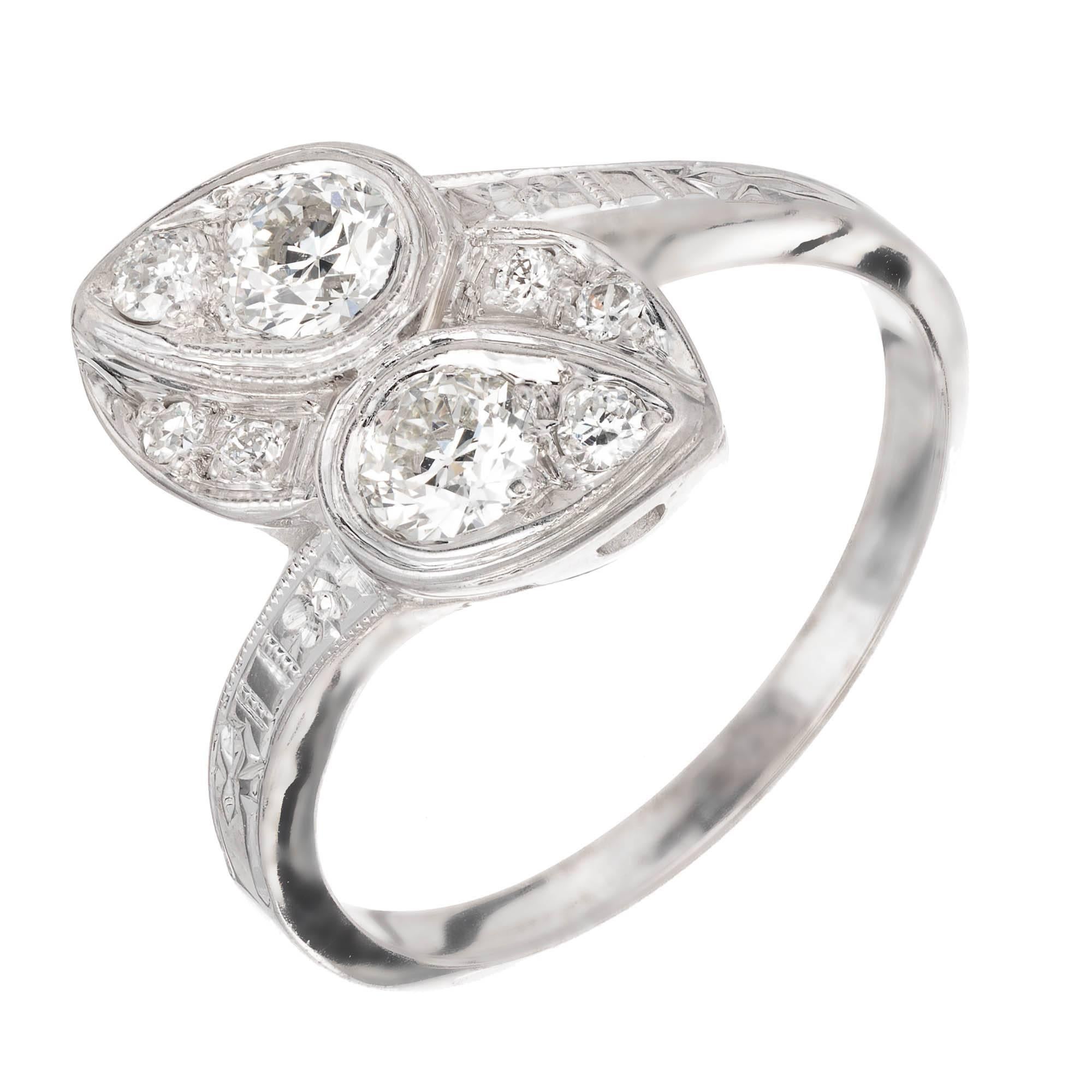 Diamond 14k white gold bypass ring. Two main round diamonds set in a Lily pad design facing opposite each other to a slight diagonal. Two small round diamonds are set to make a pear appearance while additional diamonds are set off the side. Detailed