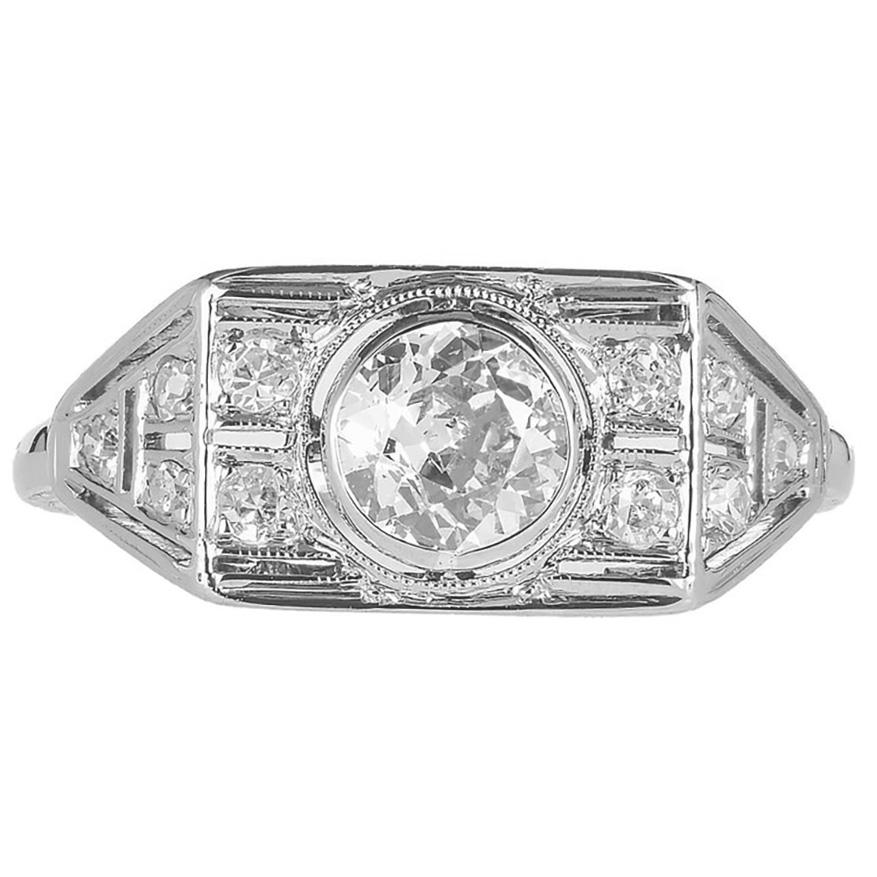 1925 Art Deco diamond white gold engagement ring. This ring is mounted with a .53ct Old European cut bezel set diamond, set in a 14k white gold mounting. The diamond is accented by 10 round Old European cut diamonds. The unique design has beaded