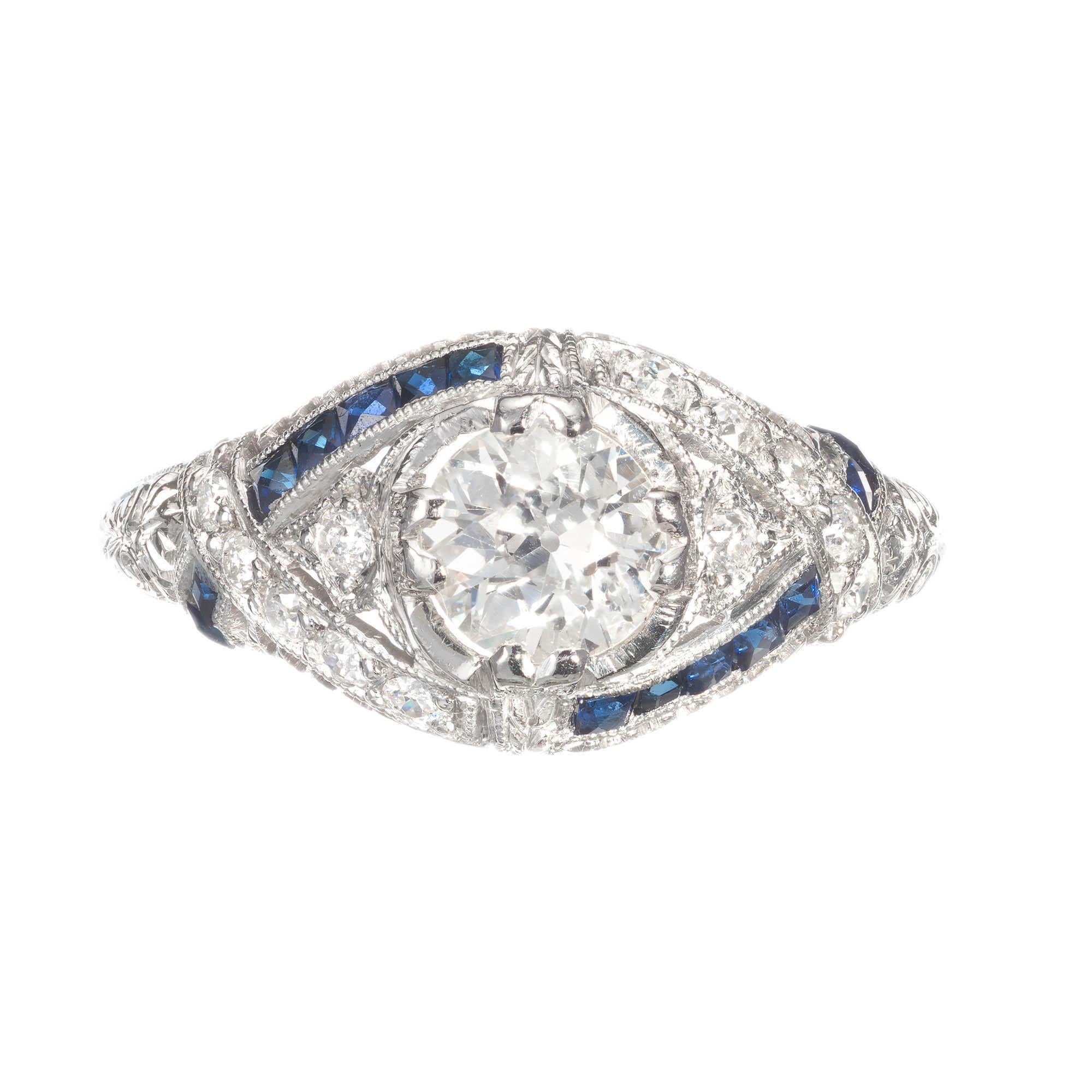 Art deco 1930s diamond pierced and engraved platinum engagement ring. Old European cut diamond with raised crown and small table for extra sparkle. French cut channel set sapphires and round diamonds accent the center stone. 

1 old European cut