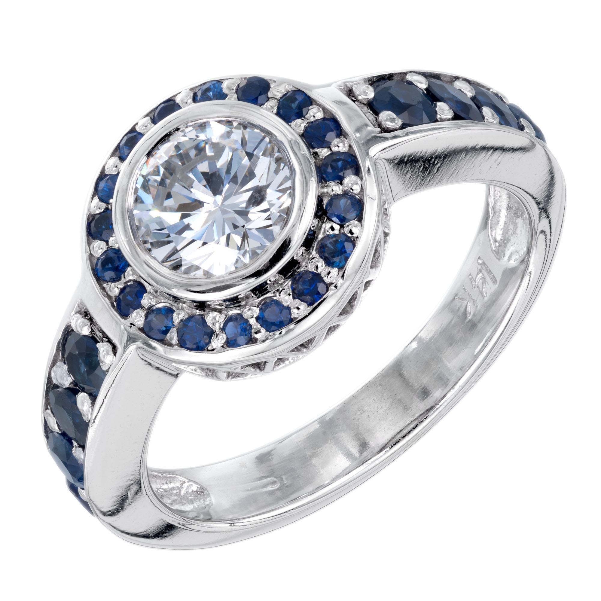 .80 carat white diamond center stone.  EGL certified in a 14k white gold setting with a halo of round sapphires. 

1 round brilliant cut diamond G-H SI2, approx. .80ct EGL US 400136327D
26 round blue sapphires, approx. .74cts
Size 6.5 and