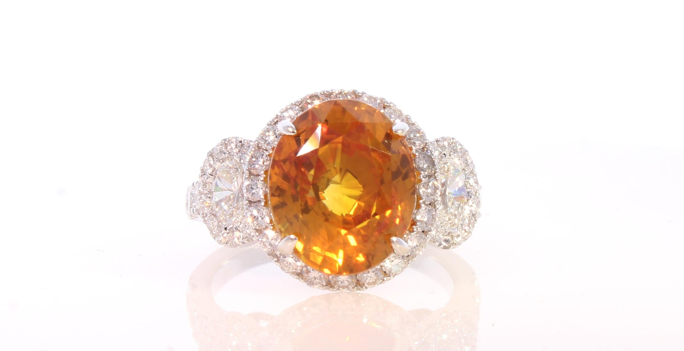 This EGL certified 6.60 carat vibrant orange sapphire, oval cut and prong set, is the star of this cocktail ring. The gem source is Sri Lanka; its color is vivid orange, its transparency and luster are excellent. It measures 11.42x9.57x6.96mm. 2