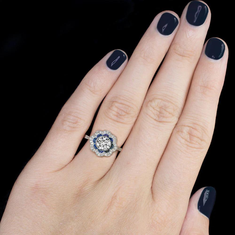 Este precioso anillo con halo de inspiración vintage presenta un vibrante diamante de talla redonda de 0,91 quilates, certificado por EGL-USA con color E y claridad SI1, que ofrece un aspecto blanco brillante y limpio a la vista. 

El diamante está