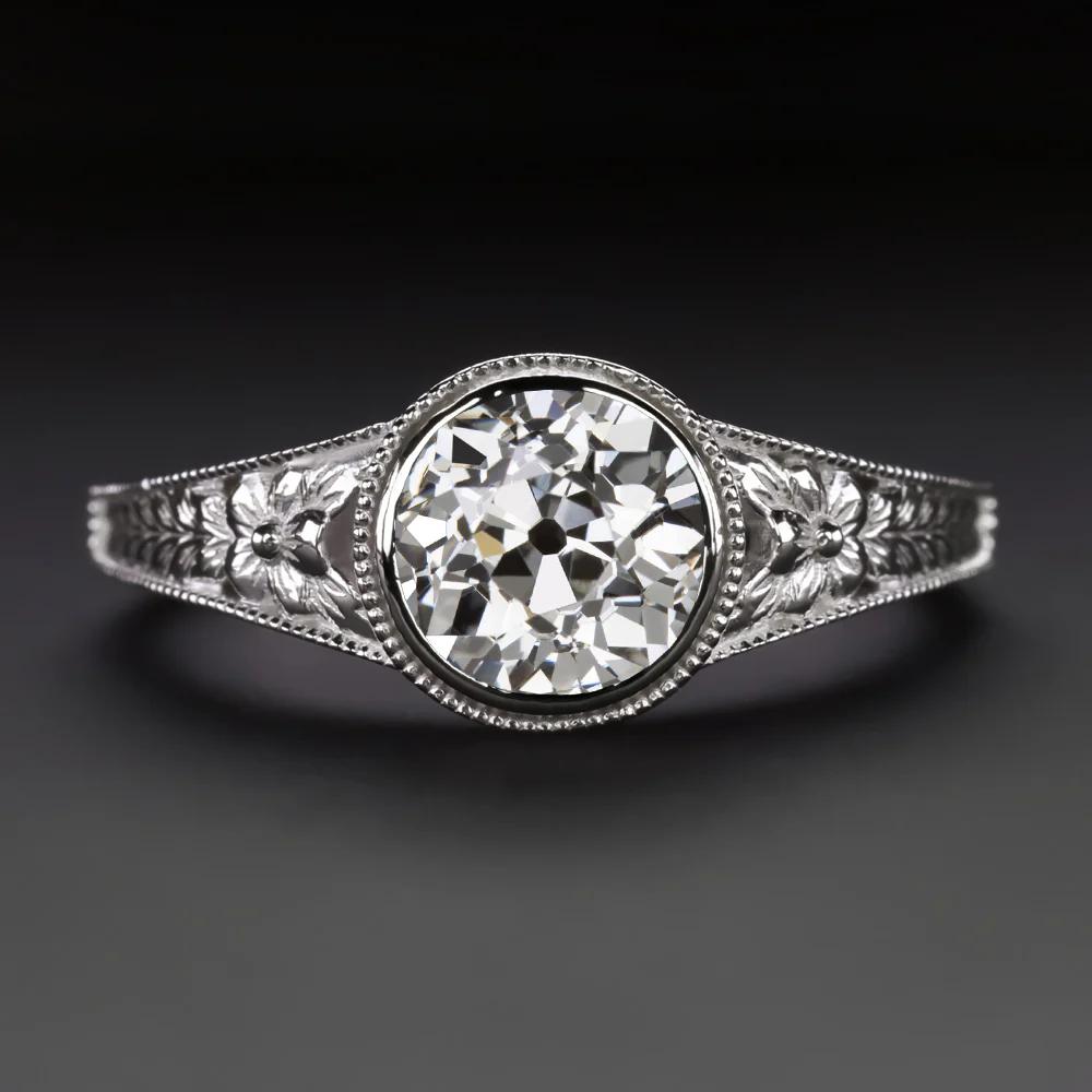 L'eleganza senza tempo incontra l'artigianato romantico in questo anello solitario in platino di ispirazione vintage, con un luminoso diamante Old European Cut da 0,93 carati incastonato in una fascia floreale finemente dettagliata.

💎 Pietra