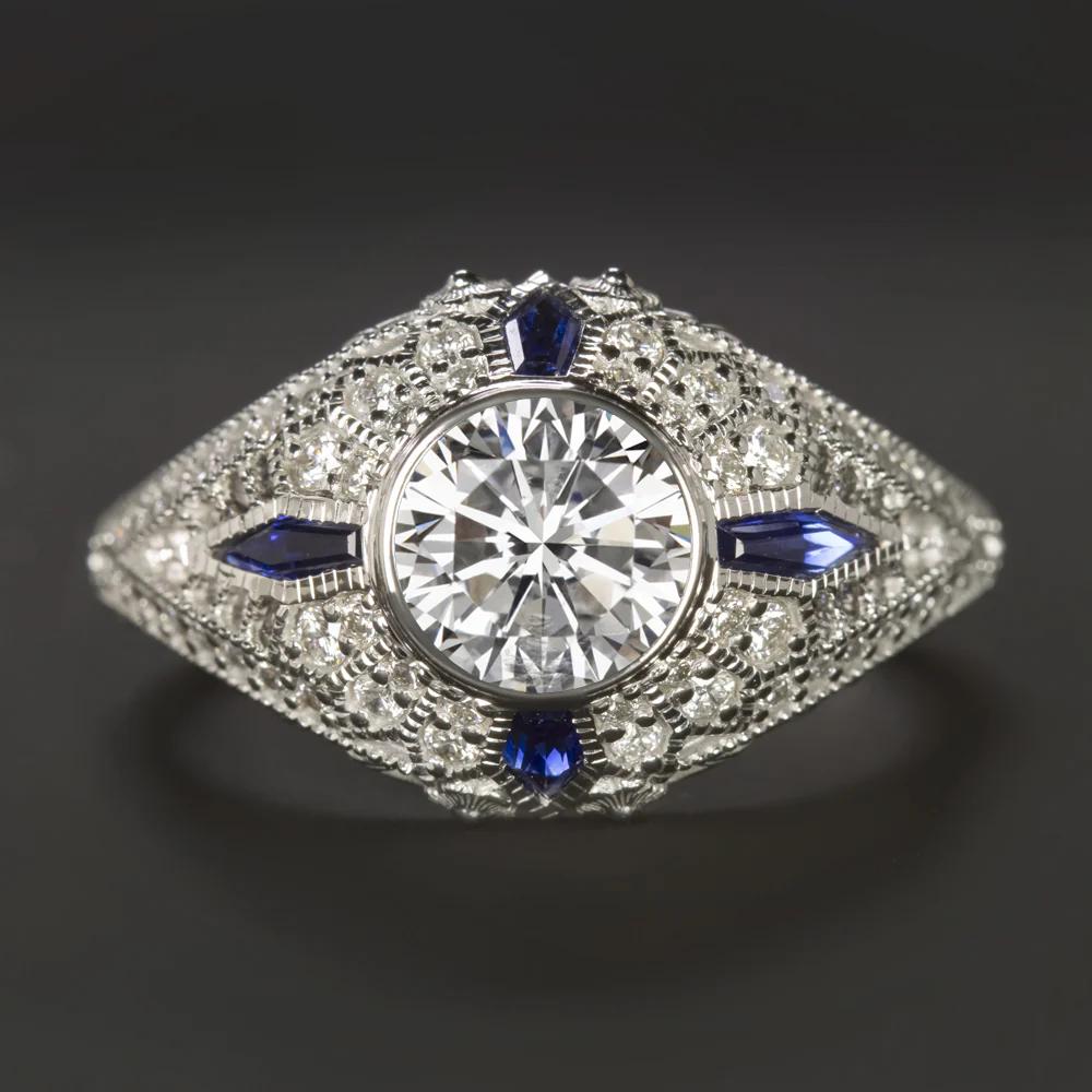 This vintage-inspired diamond and sapphire ring captures the elegance of the Art Deco era with a bold, domed design. At the center is a vibrant 1.02 carat transitional cut diamond, EGL-USA certified, featuring a bright G color and near eye-clean SI3