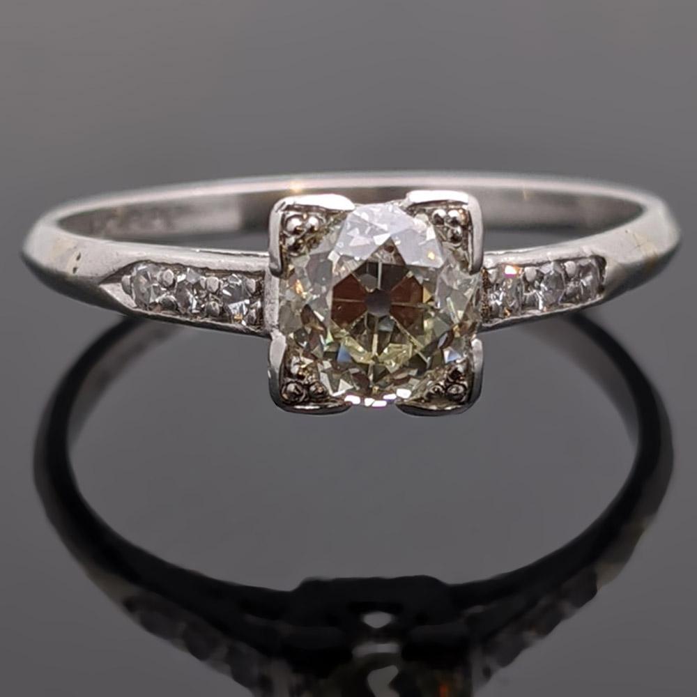 This gorgeous circa 1910s Edwardian ring is centered with an EGL USA Certified 0.76ct old european cut diamond in a four-prong square, vintage platinum setting. The shoulders are each accented with three round diamonds. Estimated weight of gold 1.5