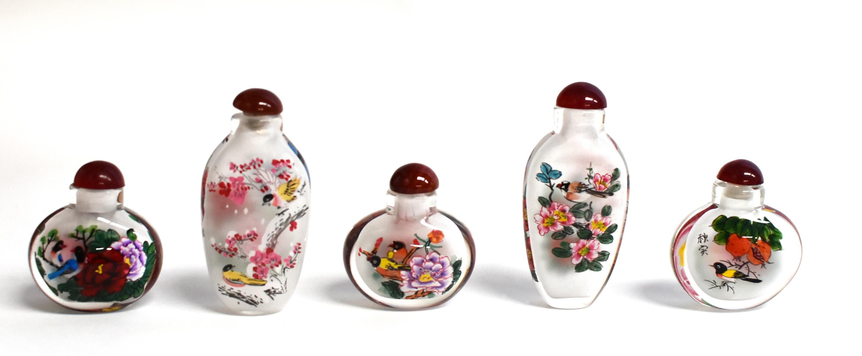 Our snuff bottles are topped with gemstone grade agate lids and 100% hand painted from within. The Chinese art of églomisé uses a very thin bamboo brush with a few strands of hair to apply watercolor on the inside walls of the blank glass bottle