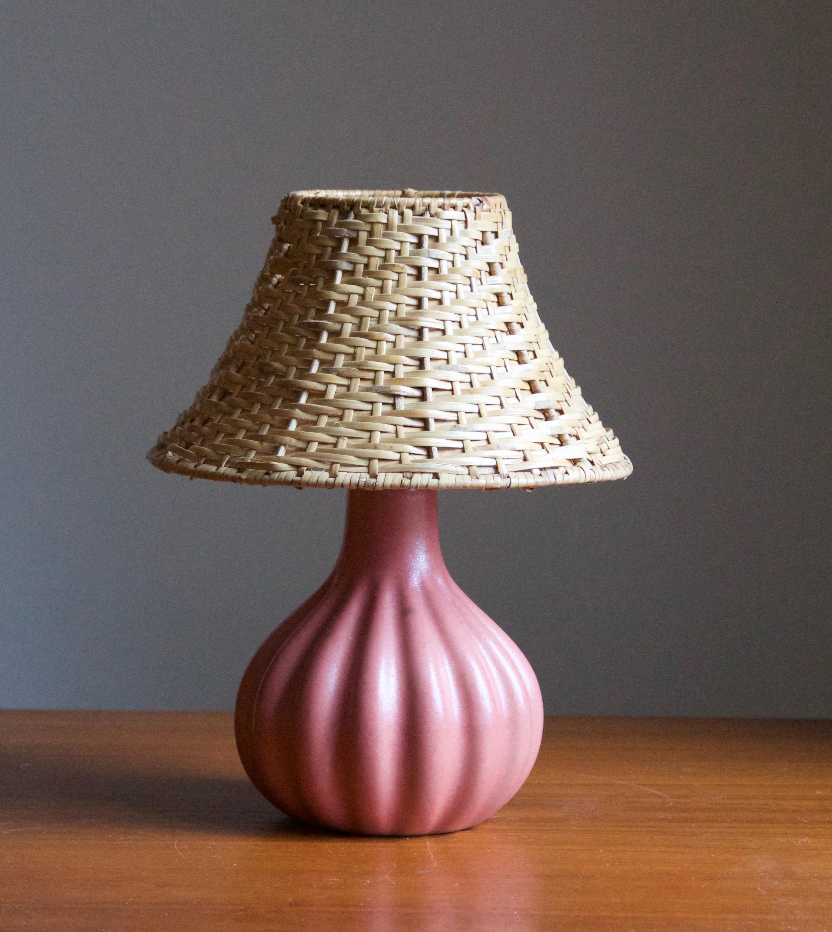 A stoneware table lamp. Produced by Ego Stengods c. 1960s-1970s. Stamped.

Stated dimensions exclude lampshade. Height including socket. Illustrated model vintage rattan lampshade can be included in purchase upon request.

Other ceramicists of