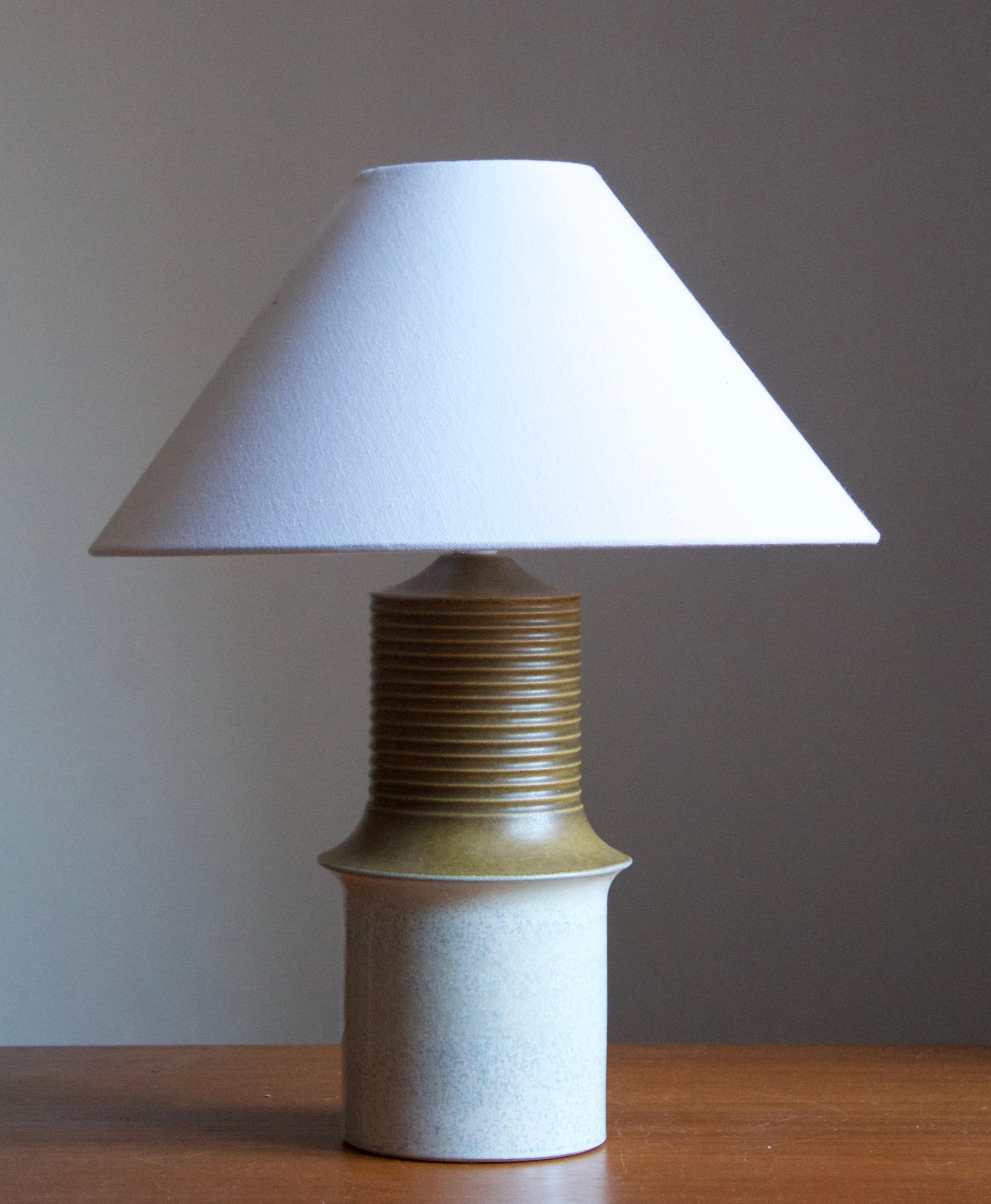 A sizeable stoneware table lamp. Produced by Ego Stengods c. 1960s. Stamped.

Stated dimensions exclude lampshade. Height including socket. Sold without lampshades.

Glaze features a green-brown color and white color.

Other ceramicists of the