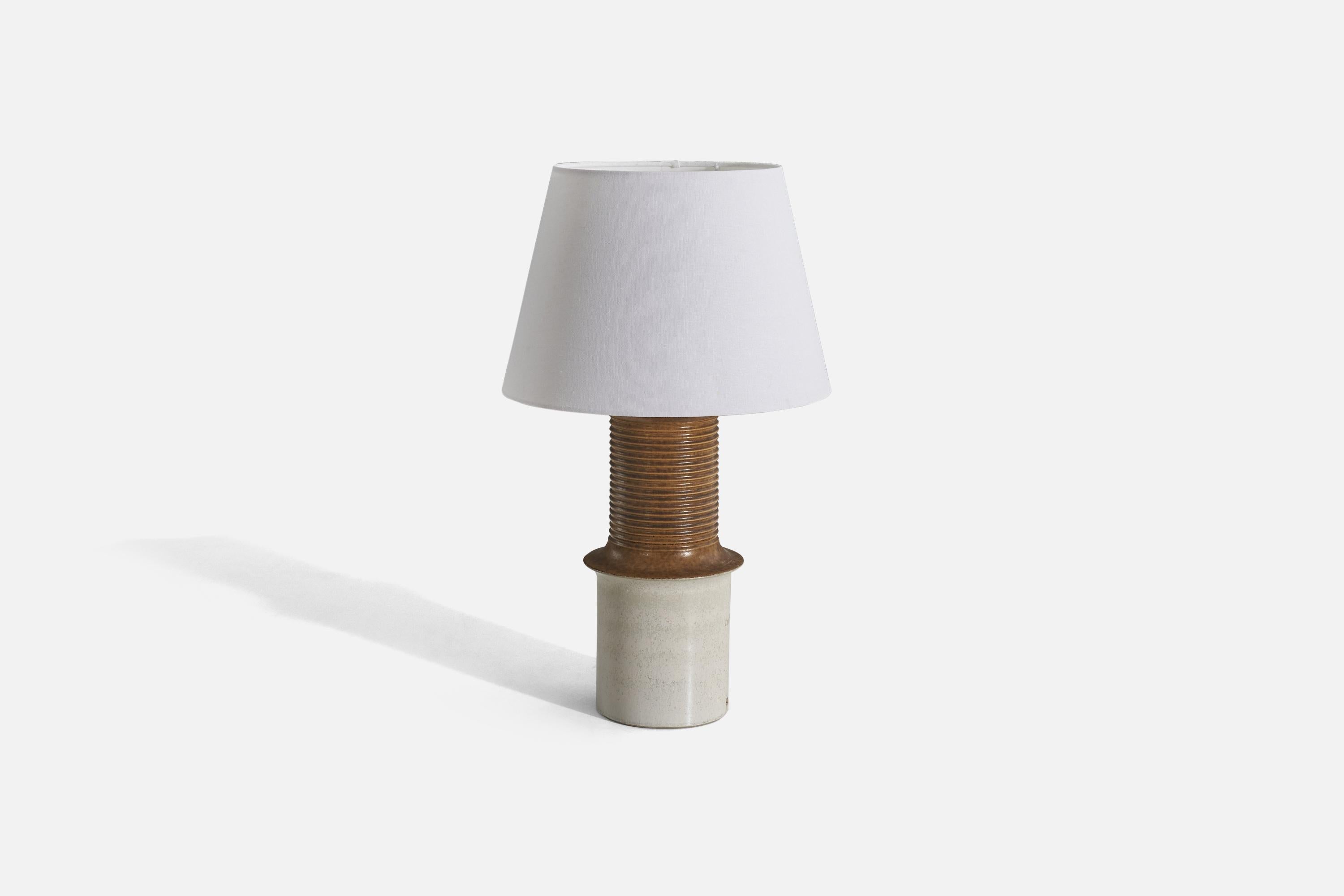 A white and brown-glazed stoneware and fabric table lamp designed and produced by Ego Stengods, Sweden, c. 1960s.

Sold with lampshade. 
Dimensions of lamp (inches) : 17.06 x 6.93 x 6.93 (height x width x depth)
Dimensions of shade (inches) :
