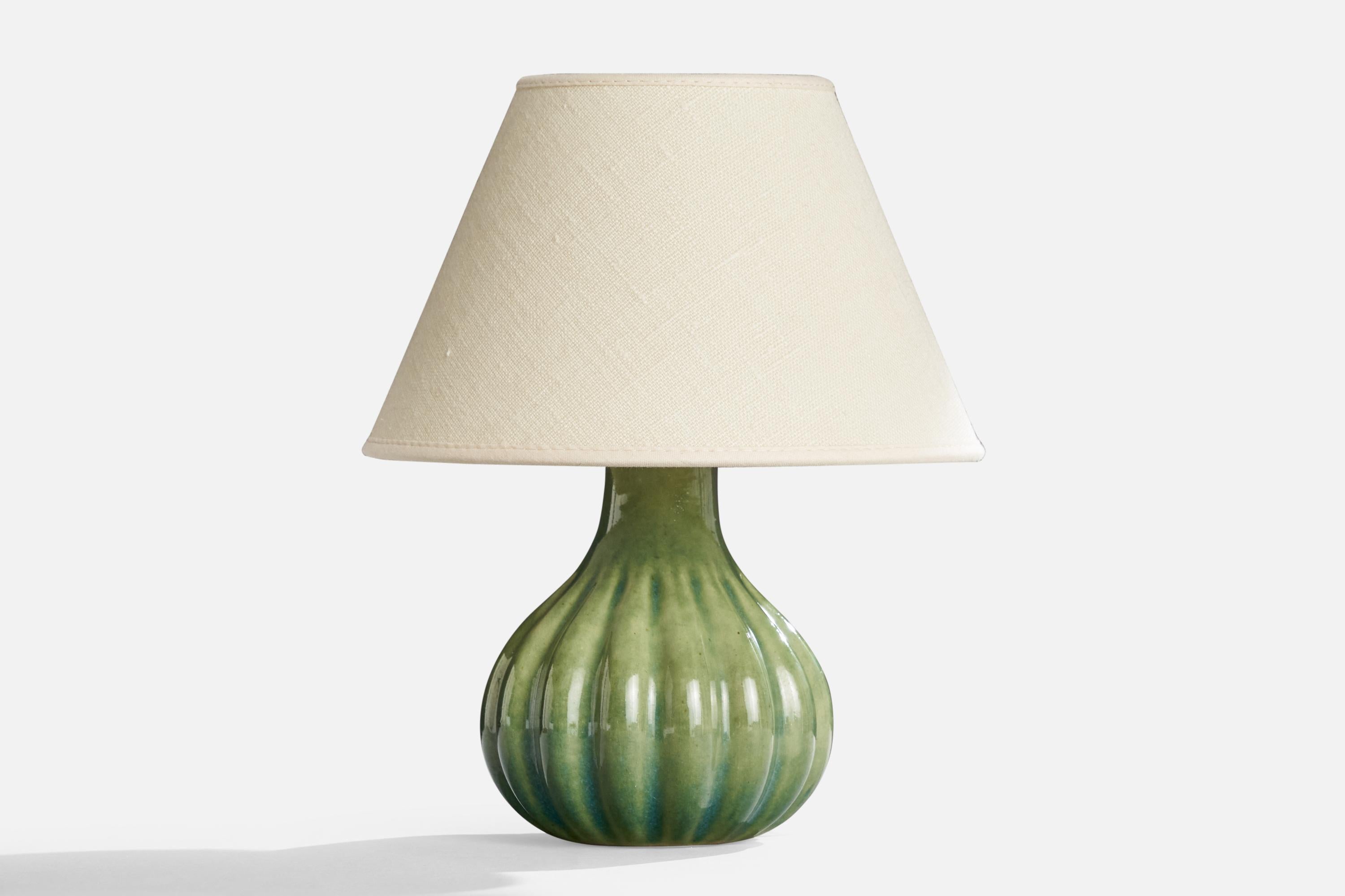 A fluted green-glazed stoneware table lamp designed and produced by Ego Stengods, Sweden, 1960s.

Dimensions of Lamp (inches): 7.3” H x 4.75” Diameter

Dimensions of Shade (inches): 4” Top Diameter x 8” Bottom Diameter x 5.25” H

Dimensions of Lamp
