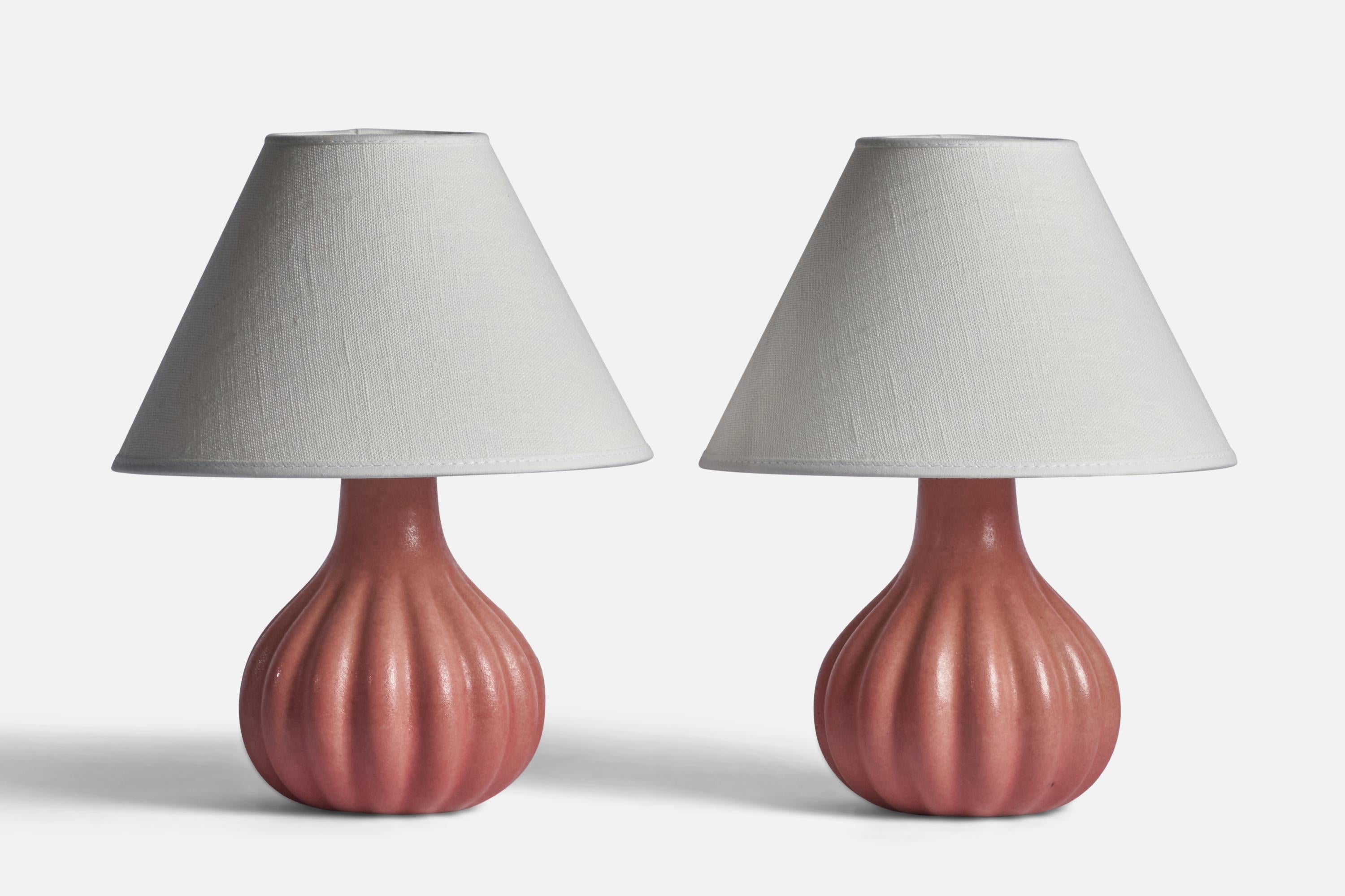 A pair of fluted pink-glazed stoneware table lamps designed and produced by Ego Stengods, Sweden, 1960s.

Dimensions of Lamp (inches): 7.25” H x 5” Diameter
Dimensions of Shade (inches): 3” Top Diameter x 8” Bottom Diameter x 5.4” H
Dimensions of