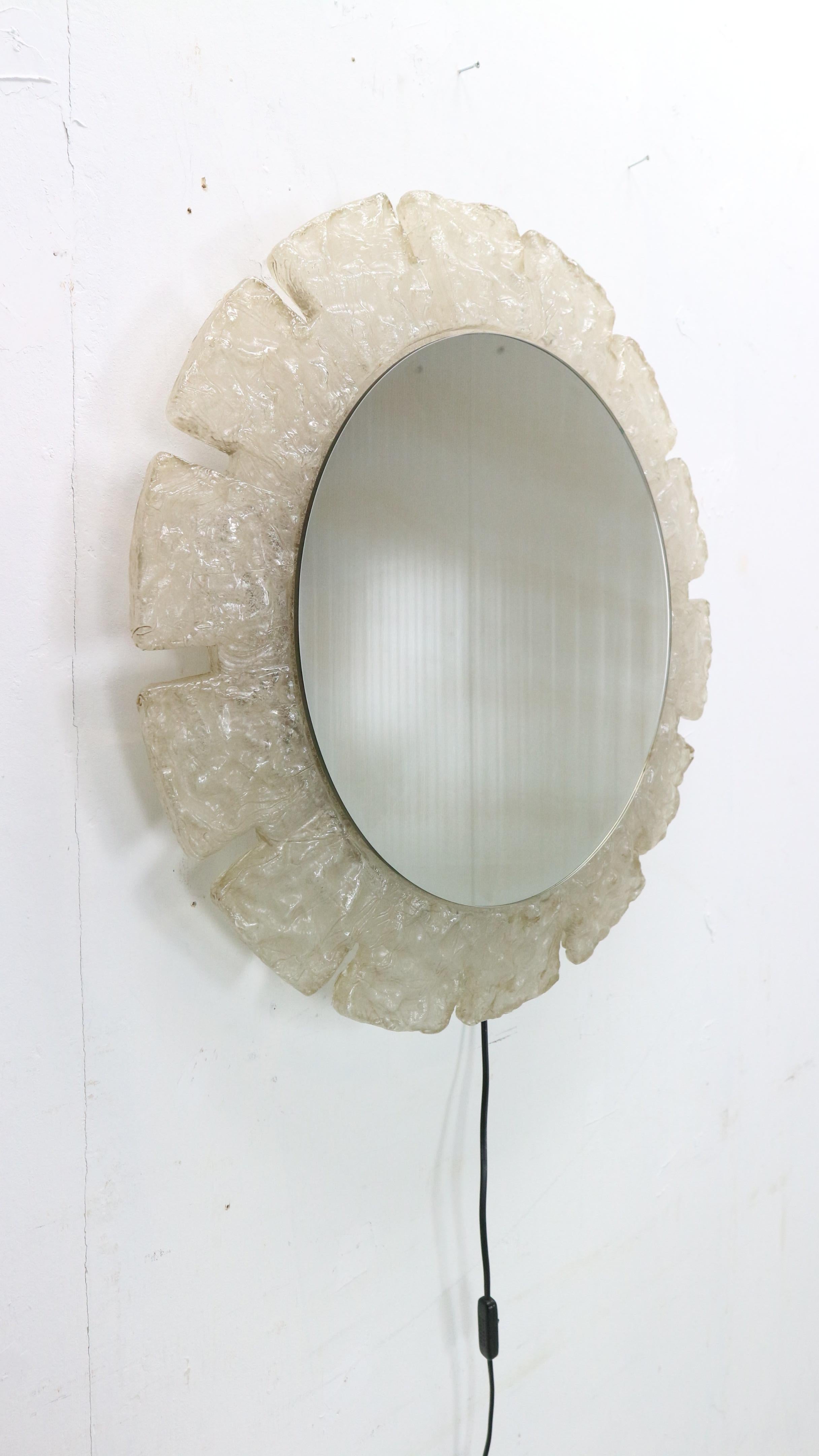 Der runde Spiegel wurde von Egon Hillebrand entworfen, 1960er Jahre, Deutschland.
Er besteht aus Metall mit Plexiglas um den Spiegel selbst. Drei Innenbeleuchtungen, die ein warmes, weiches Licht ausstrahlen, wenn sie eingeschaltet sind. 
Der