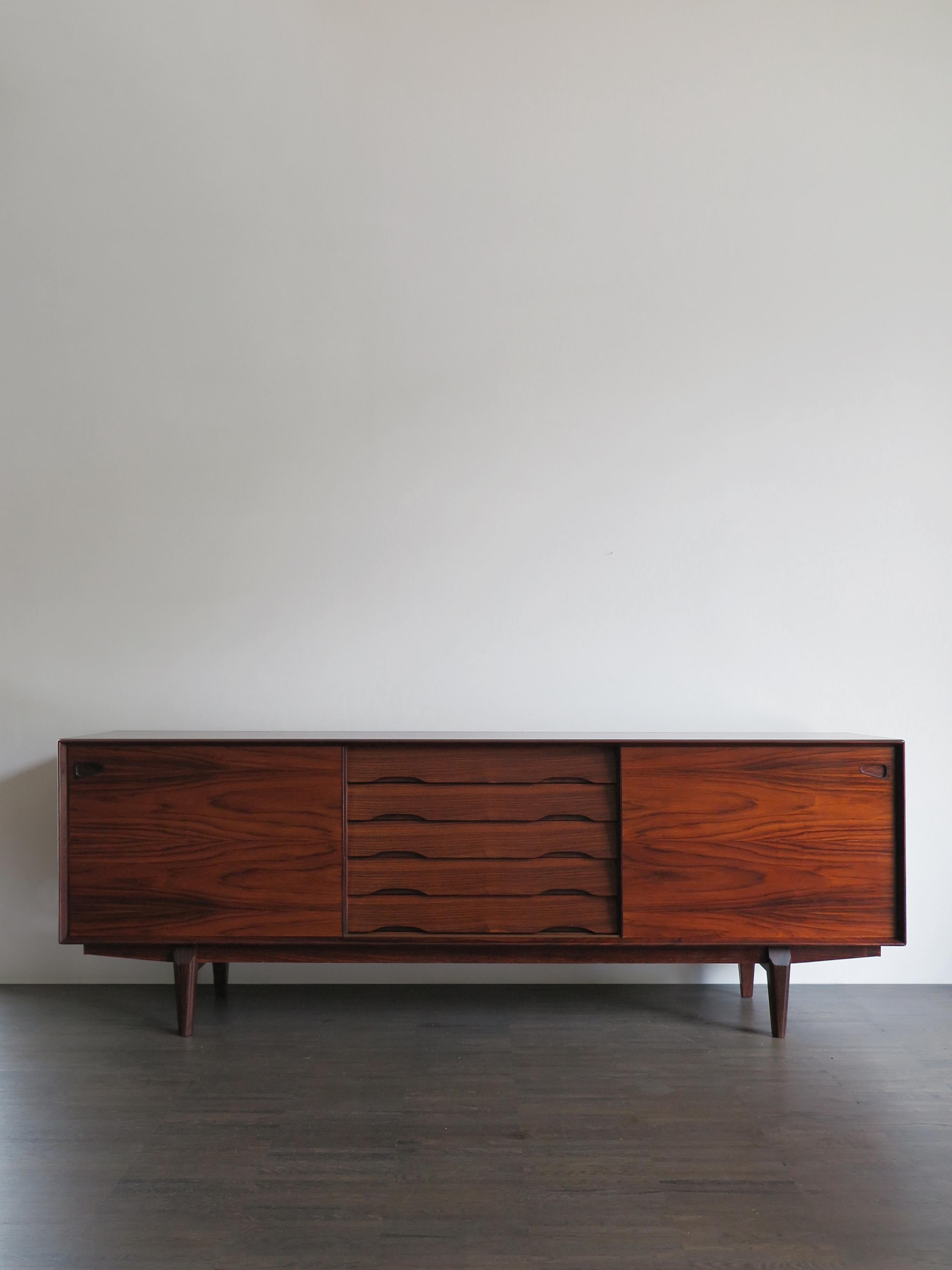 Scandinavian Mid-Century Modern design rosewood sideboard
designed by Egon Kristensen for Skovby with five chest of drawers and two big sliding doors,
produced in Denmark from 1950 circa.

Please note that the sideboard is original of the period