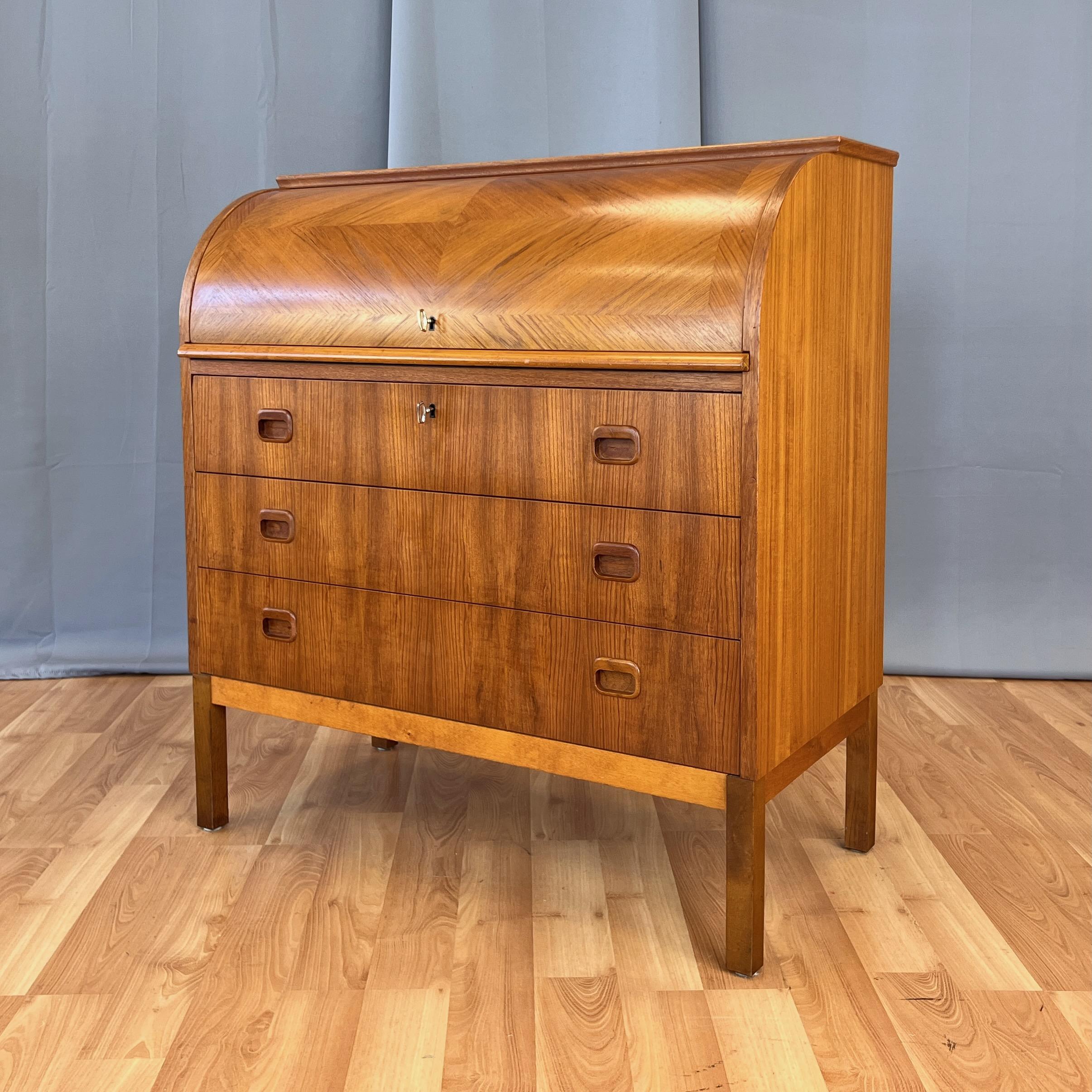 Secrétaire en teck moderne scandinave de la fin des années 1960 avec surface d'écriture extractible et tiroirs multiples par Egon Ostergaard pour Svensk Mobelindustri de Suède.

Le plateau roulant verrouillable en forme de cylindre présente un motif