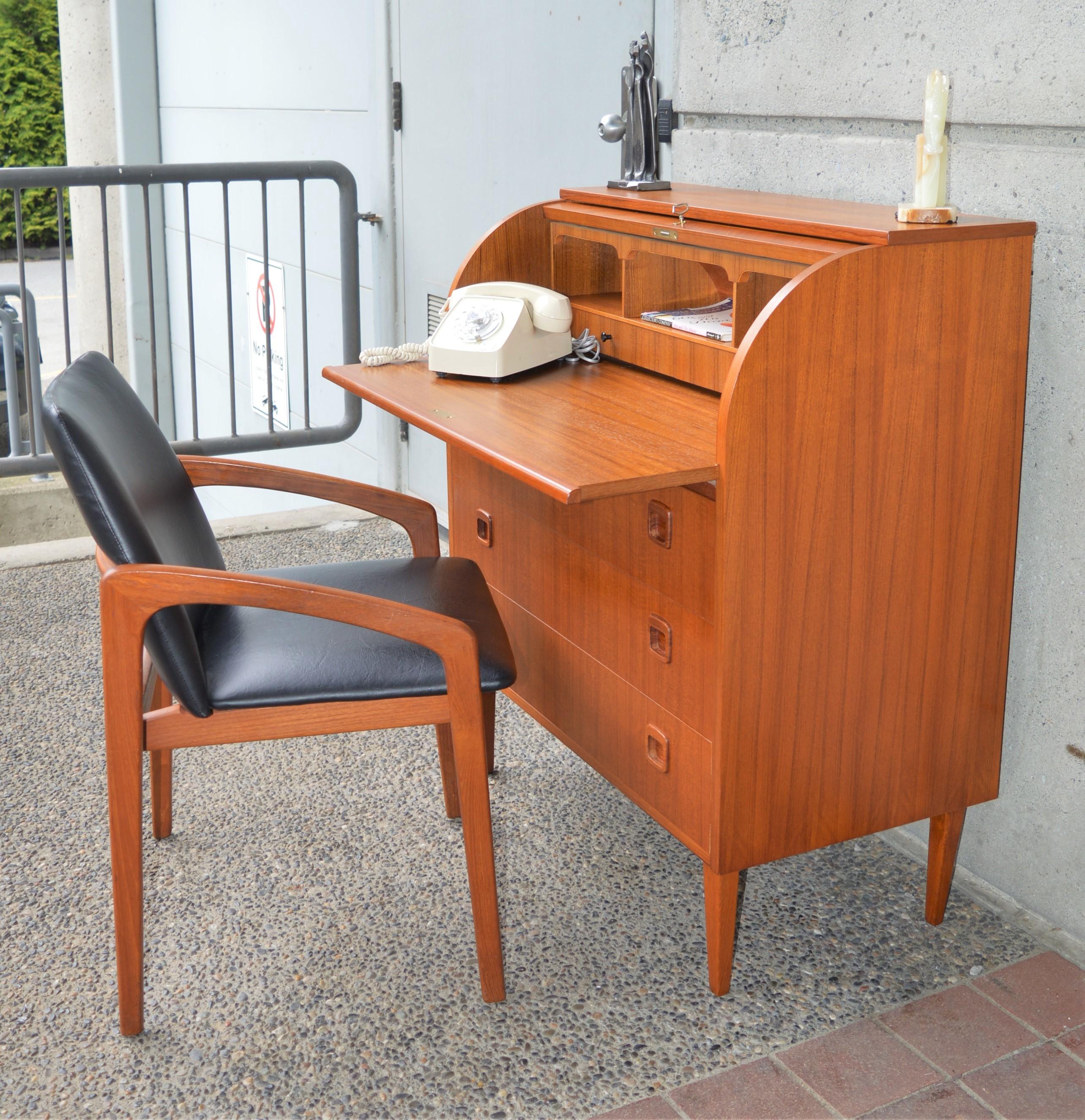 This gorgeous Danish modern teak barrel top dresser doubles as a handy secretary desk or writing table with a pullout / pull-out desk top and small upper drawers and pigeon holes that can all be hidden behind the beautifully curved drop down door