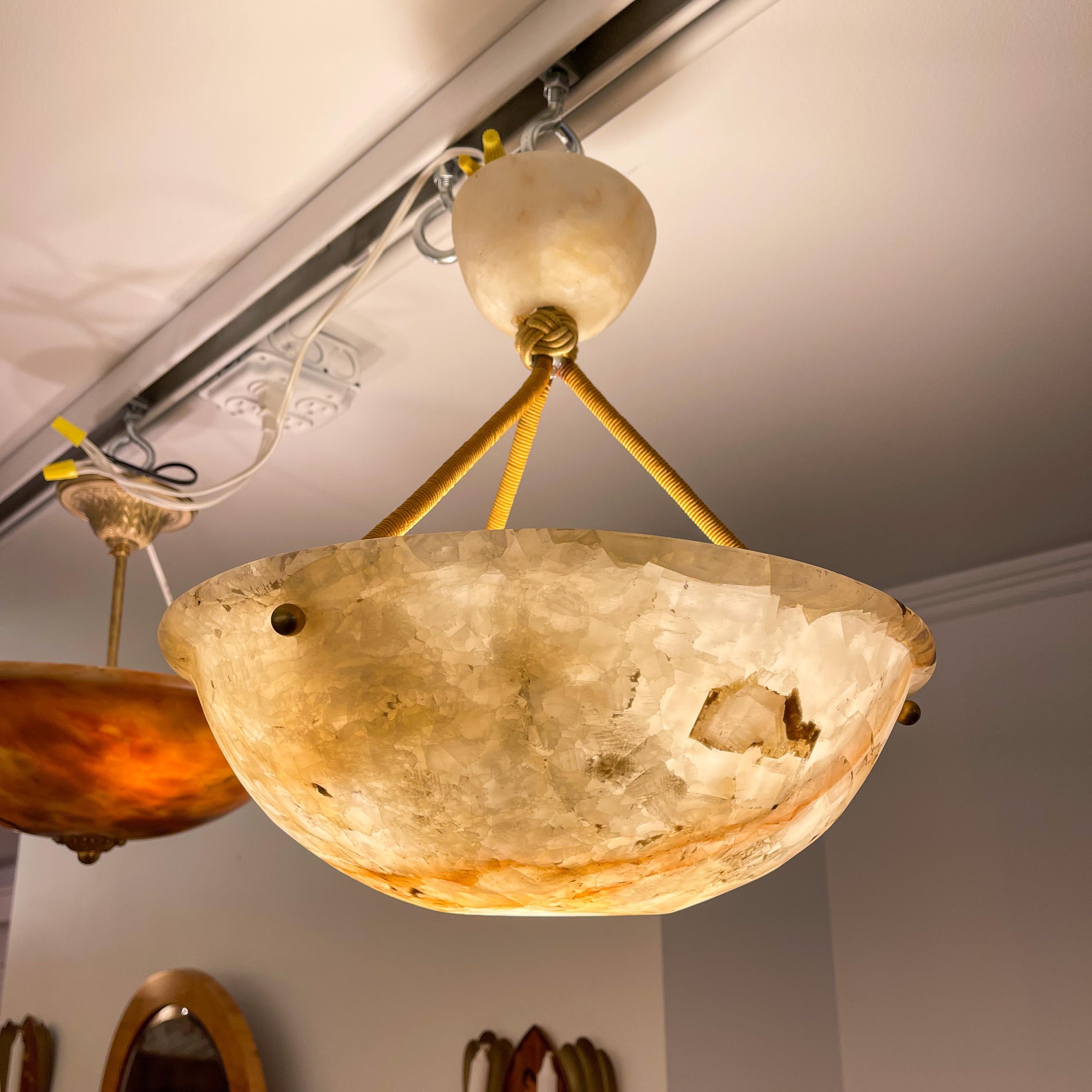 Carved from a single block of sandy colored alabaster, this fixture has a lively translucent glow to complement heavy mineralization. Canopy is matching, and drop may be custom specified at no additional charge. The depth of the bowl itself is 4.5