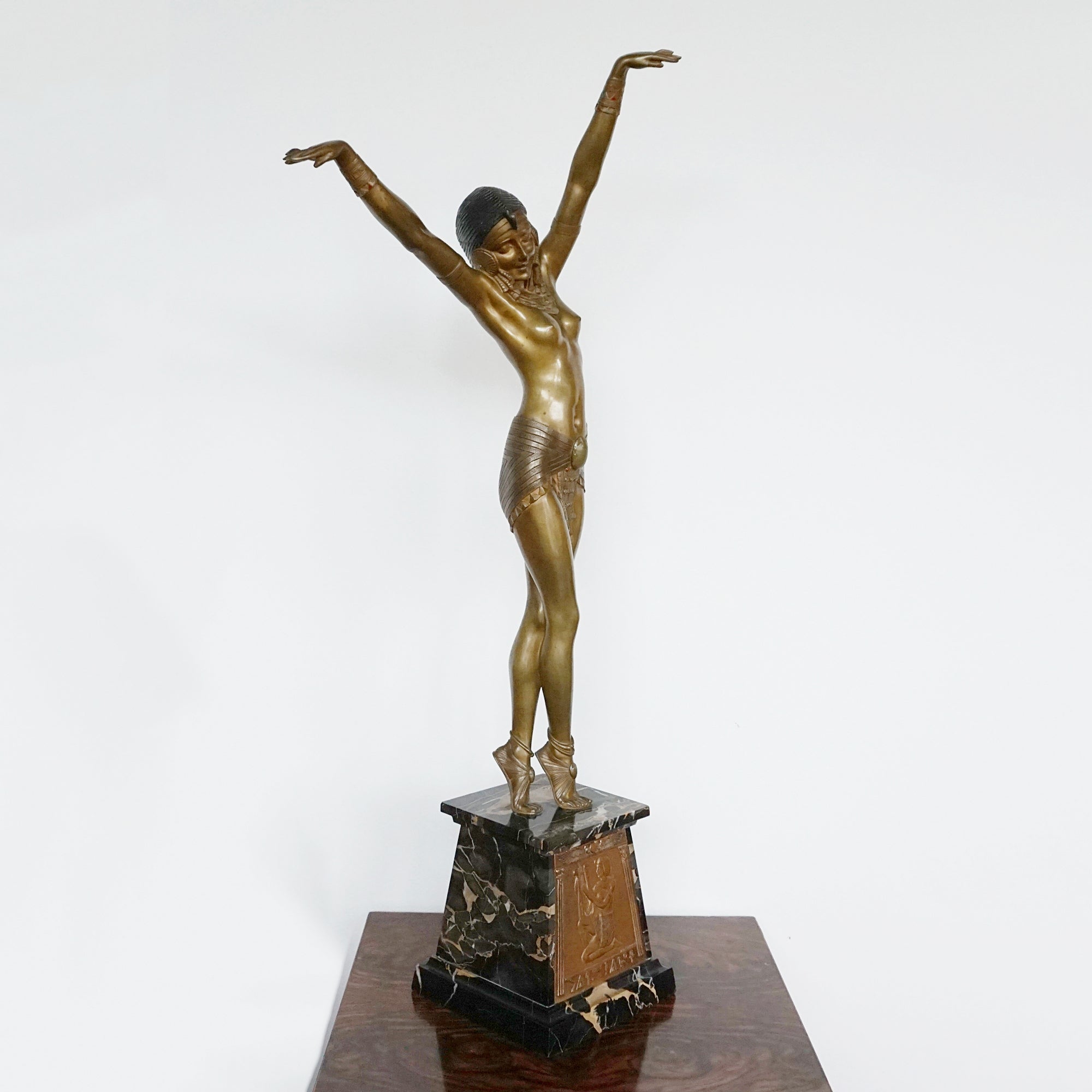 'Egyptian Dancer' by Demetre Chiparus. A cold painted bronze sculpture of a dancer dressed in Egyptian style scantily clad costume with her arms outstretched. Set over a marble base with front plaque. Signed 'D H. Chiparus' to base and plaque.