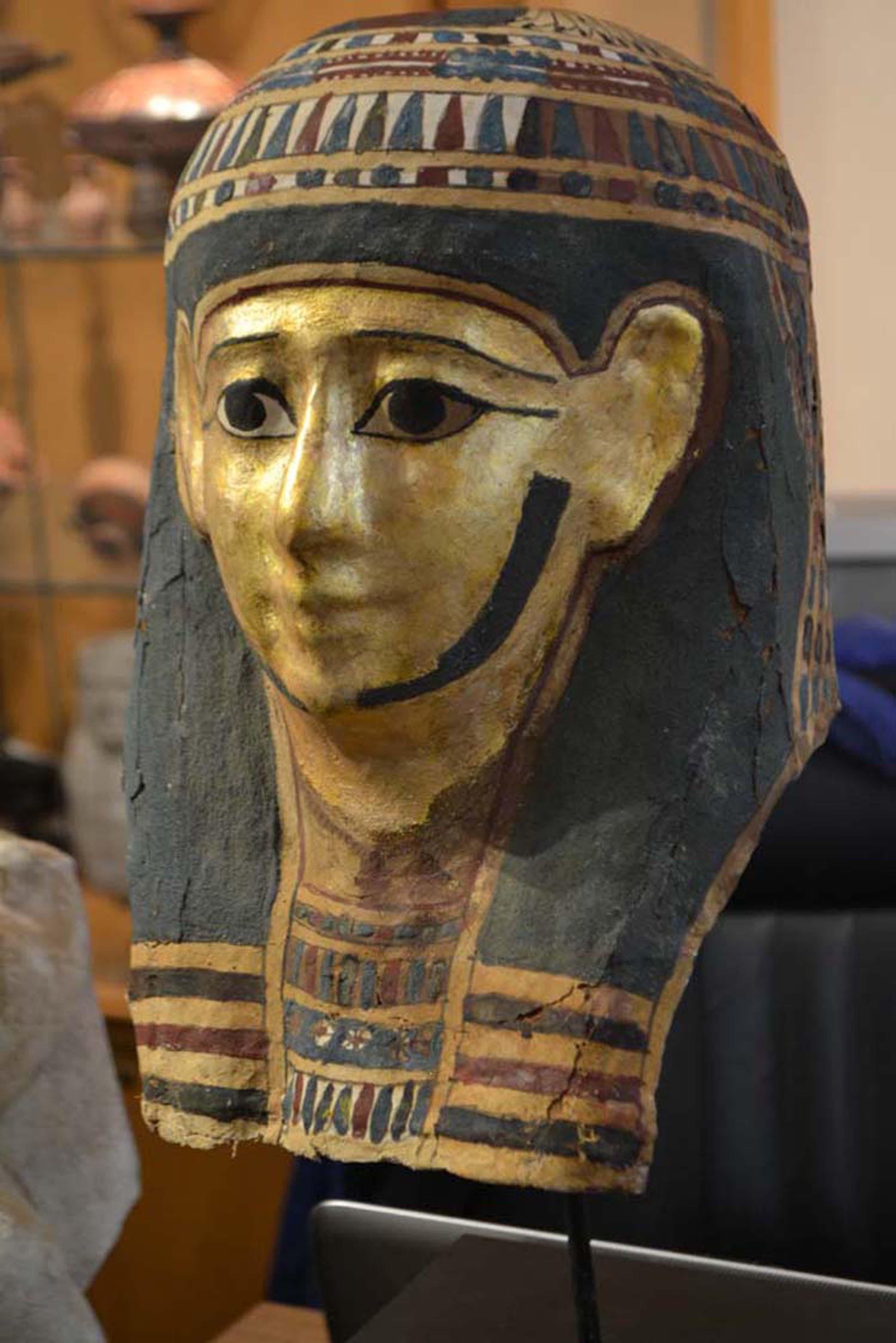 Egyptian Ptolemaic period funerary mask made in cartonnage and painted in colors and gold paint, professionally conserved with some minor over-painting. The piece is dated circa 300 to 30 BC and is mounted on a stand.