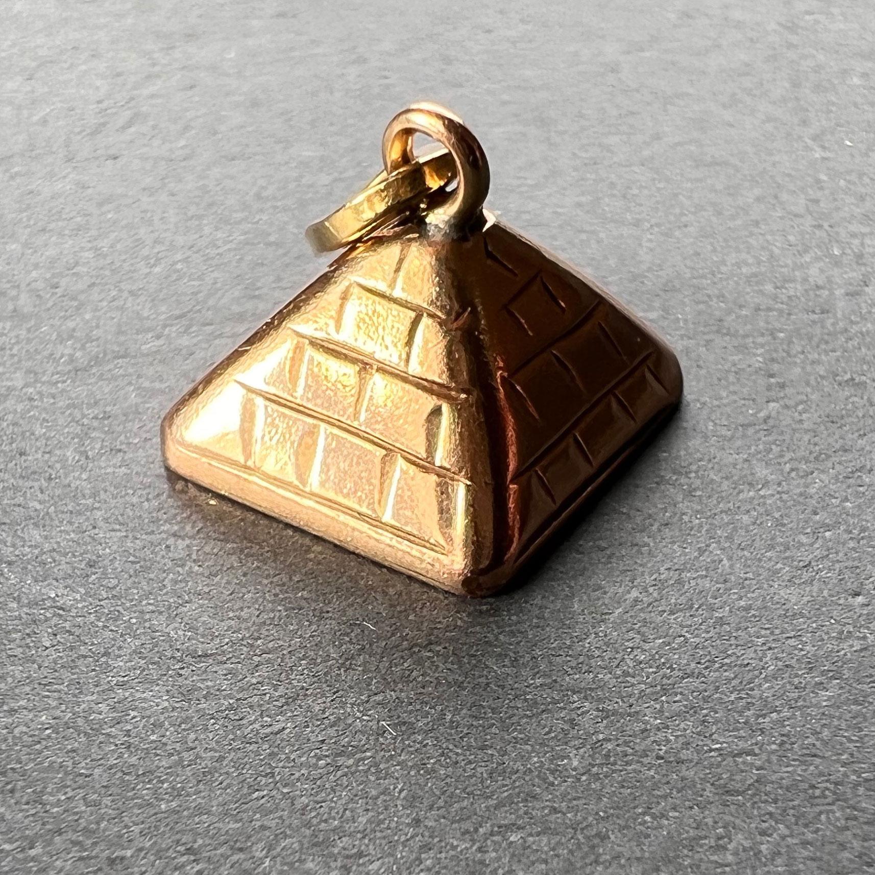 A 14 karat (14K) rose gold charm pendant designed as an Egyptian pyramid. Unmarked but tested for 14 karat gold.
 
Dimensions: 0.95 x 1.1 x 1.1 cm (not including jump ring)
Weight: 1.48 grams 
(Chain not included)
