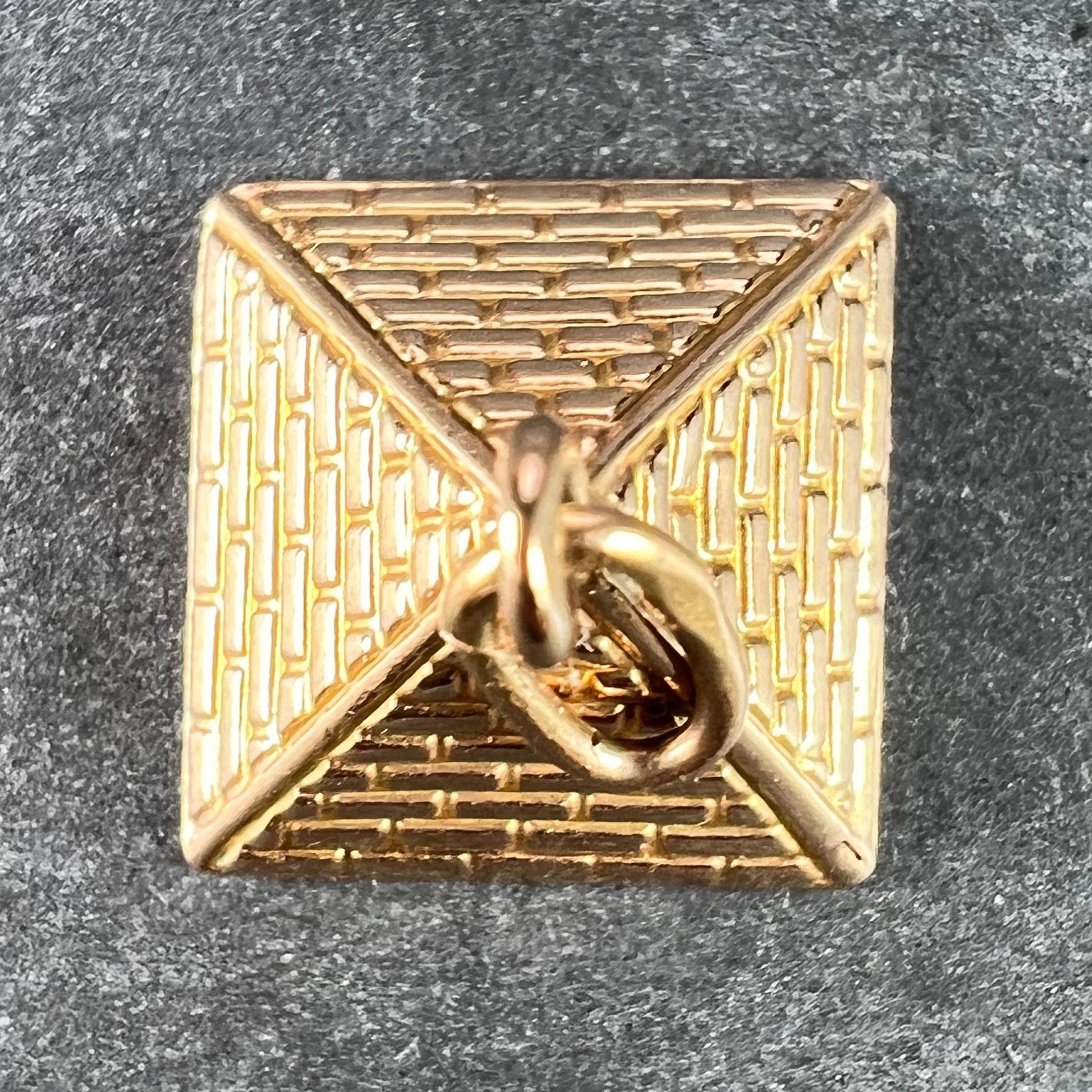  An 18 karat (18K) rose gold charm pendant designed as an Egyptian pyramid. Stamped with the Egyptian marks for 18 karat gold.
 
Dimensions: 1 x 1.2 x 1.2 cm (not including jump ring)
Weight: 1.11 grams 
(Chain not included)