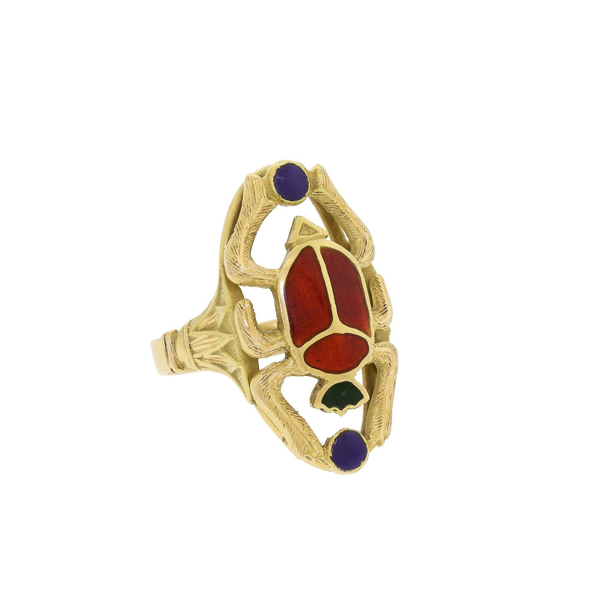 Ladies 18K yellow gold Egyptian Revival scarab ring. Originally purchased in Egypt many years ago, this ring is both striking and unique.
The body of the scarab has beautiful, deep burnt-orange enamel with green and blue accents that are quite