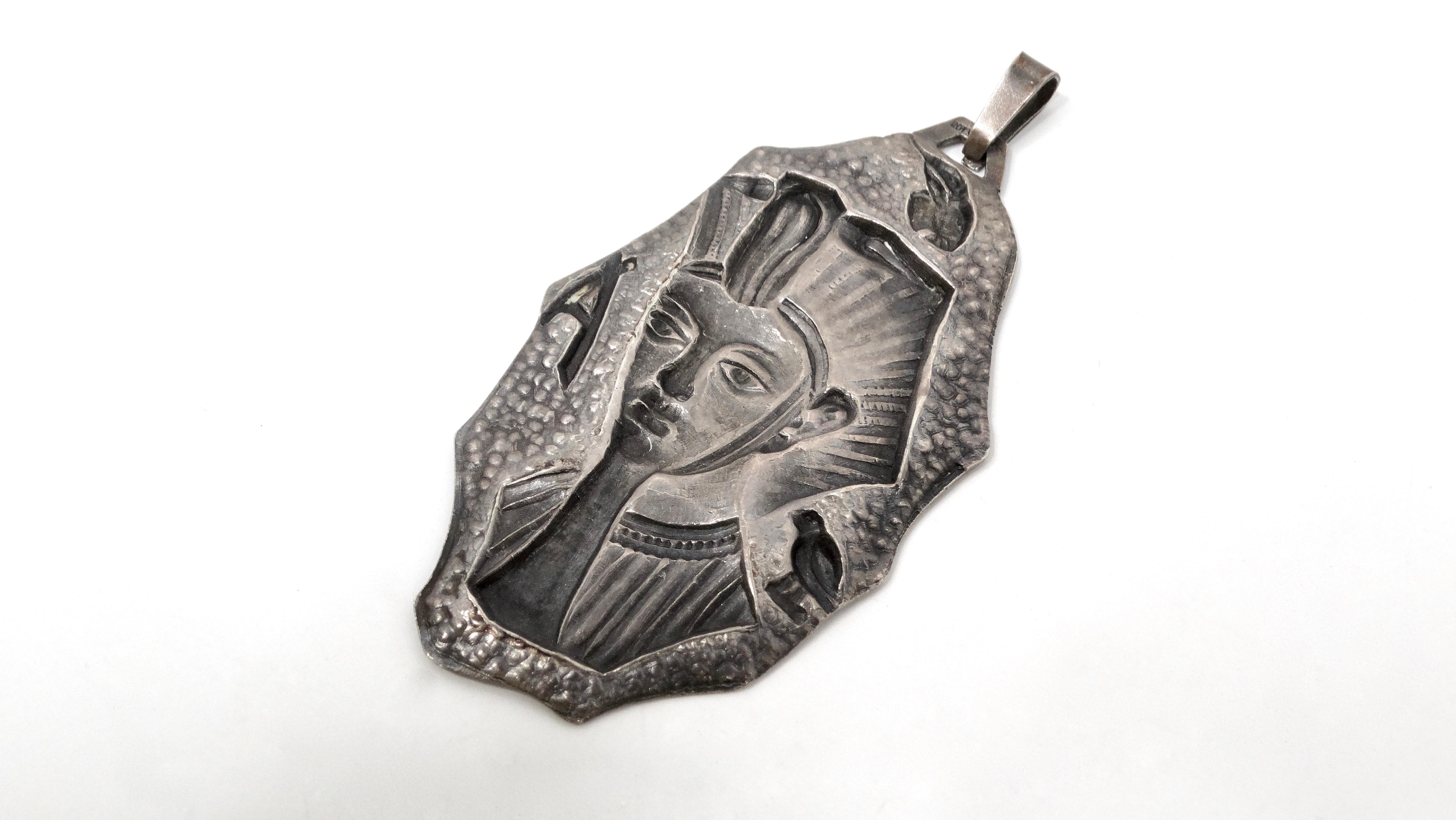 Il Ciondolo grande in argento 800 Egyptian Revival, realizzato nel 1900 circa, è una straordinaria testimonianza del fascino dei motivi egizi che si diffuse tra la fine del XIX e l'inizio del XX secolo. Questo squisito pezzo è caratterizzato da