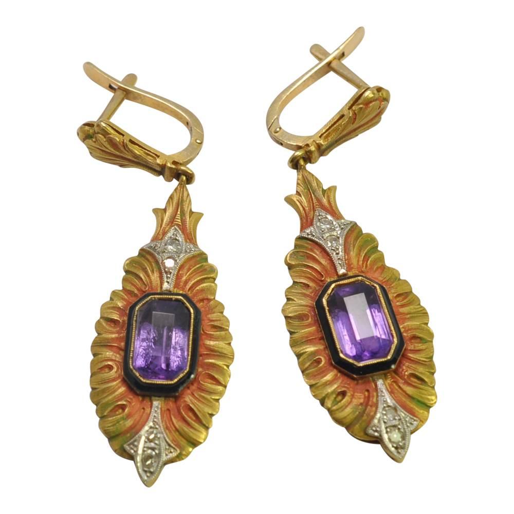 Egyptian revival amethyst and diamond ear pendants; these dramatic earrings have central, bezel set amethysts with black enamel surrounds and two small 8-cut diamonds above and below, in lotus leaf settings.  The gold is patinated in shades of red