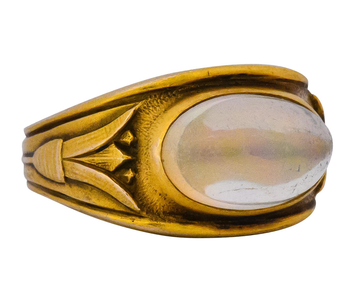 Centering a bezel set jelly opal measuring 3/8 x 9/16 inch, transparent with full spectrum of play-of-color in broad flashes

Matte gold with large stylized flowers on each shoulder

Stamped 14 with maker's mark

Circa 1905

Ring Size: 4

Measures:
