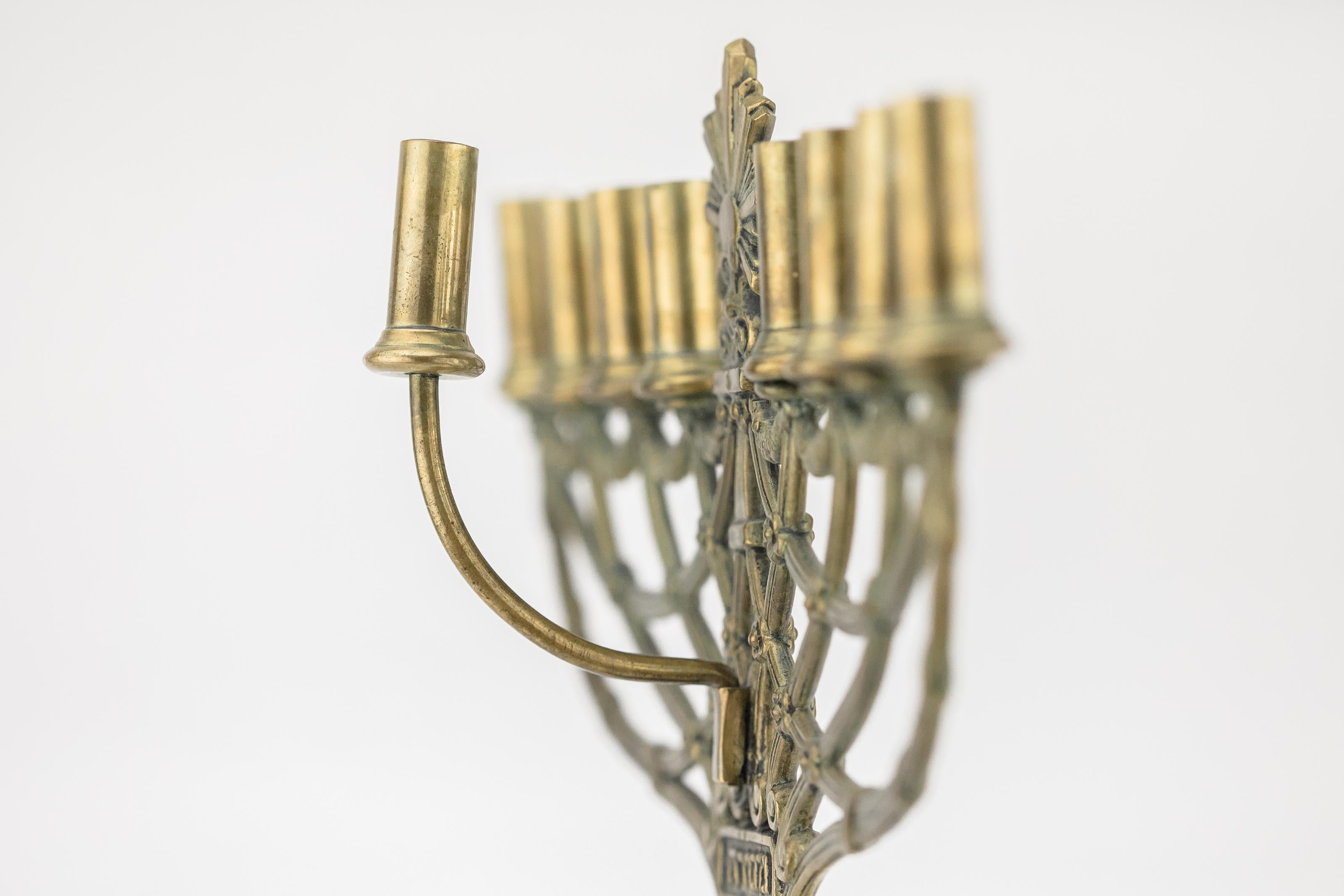Egyptian-revival Hanukkah Lamp, Germany, circa 1890.
Expertly cast brass featuring highly detailed motifs such as a Star of David in a laurel wreath, upper portion comprised of twisted-rope forms topped by swags and finished with a sunburst. On