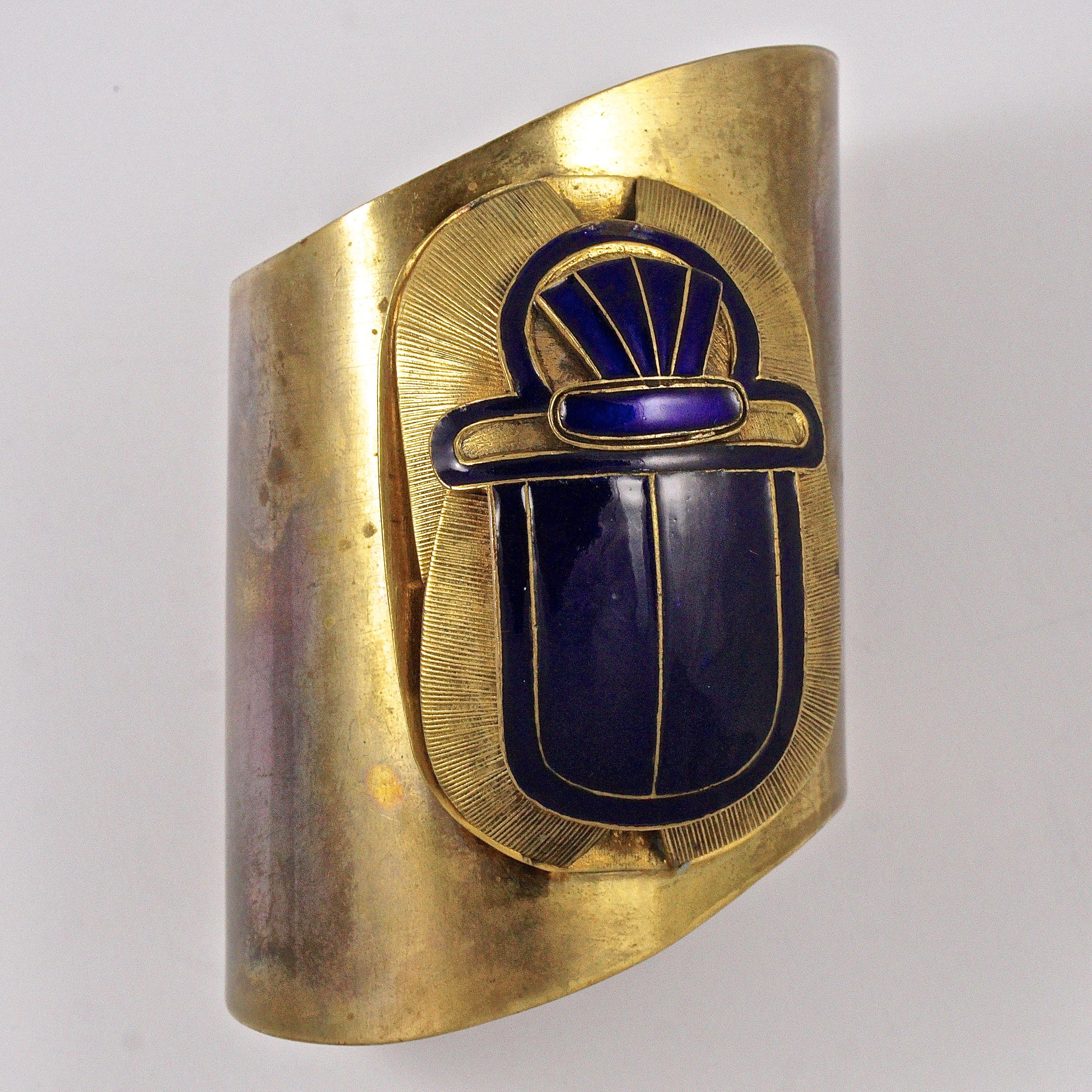 Egyptian Revival fabulous brass statement cuff bangle, featuring a large detailed blue enamel scarab. The width of the bangle is approximately 7.7cm / 3 inches tapering to 6.7cm / 2.63 inches, and the scarab is length 6.35cm / 2.5 inches. The brass