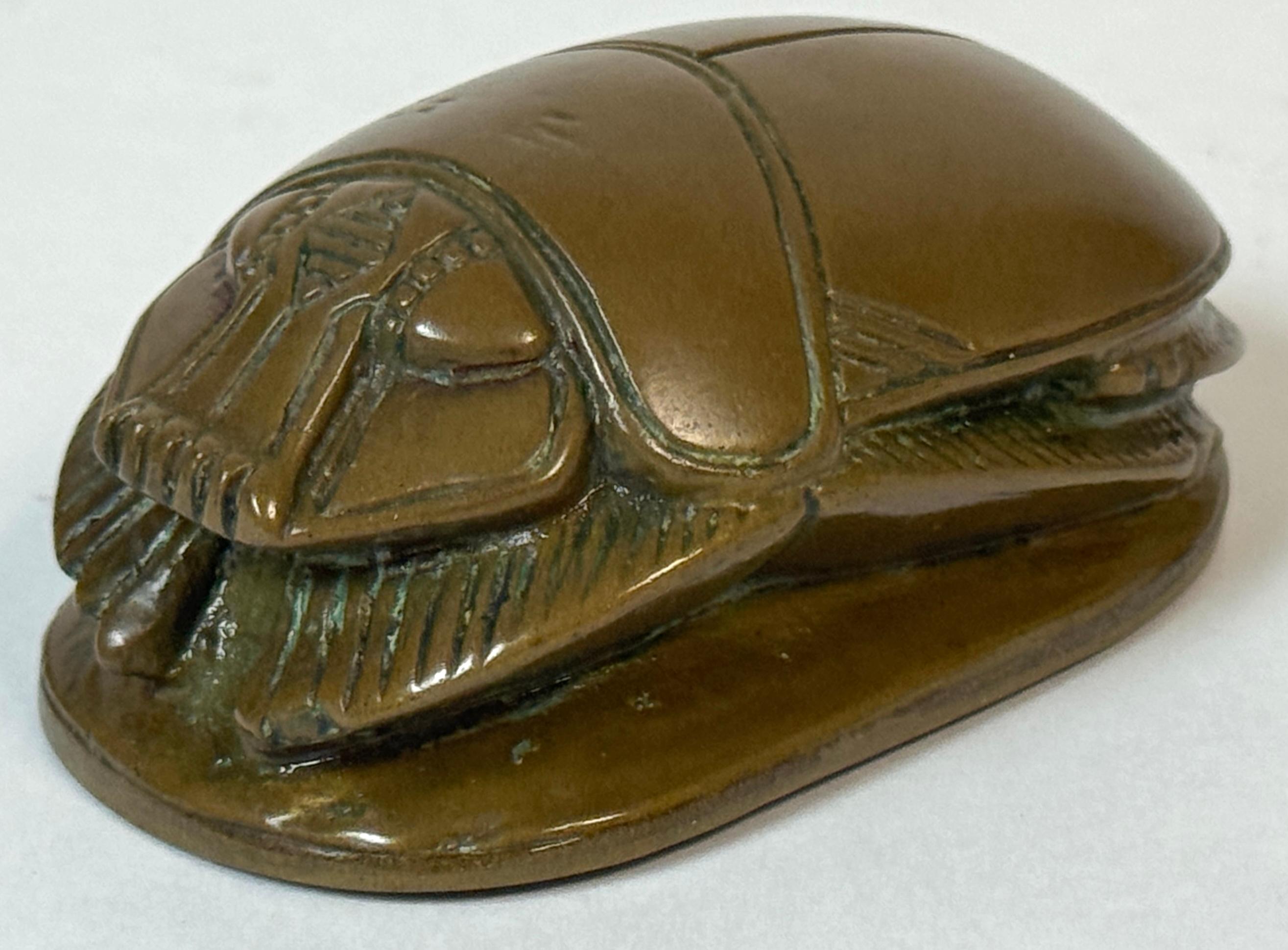 Egyptian Revival Bronze Scarab Paperweight with Hieroglyphic Inscription, Early 20th Century

A finely cast Egyptian Revival scarab paperweight in patinated bronze, richly inscribed with a hieroglyphic text on its underside in imitation of ancient